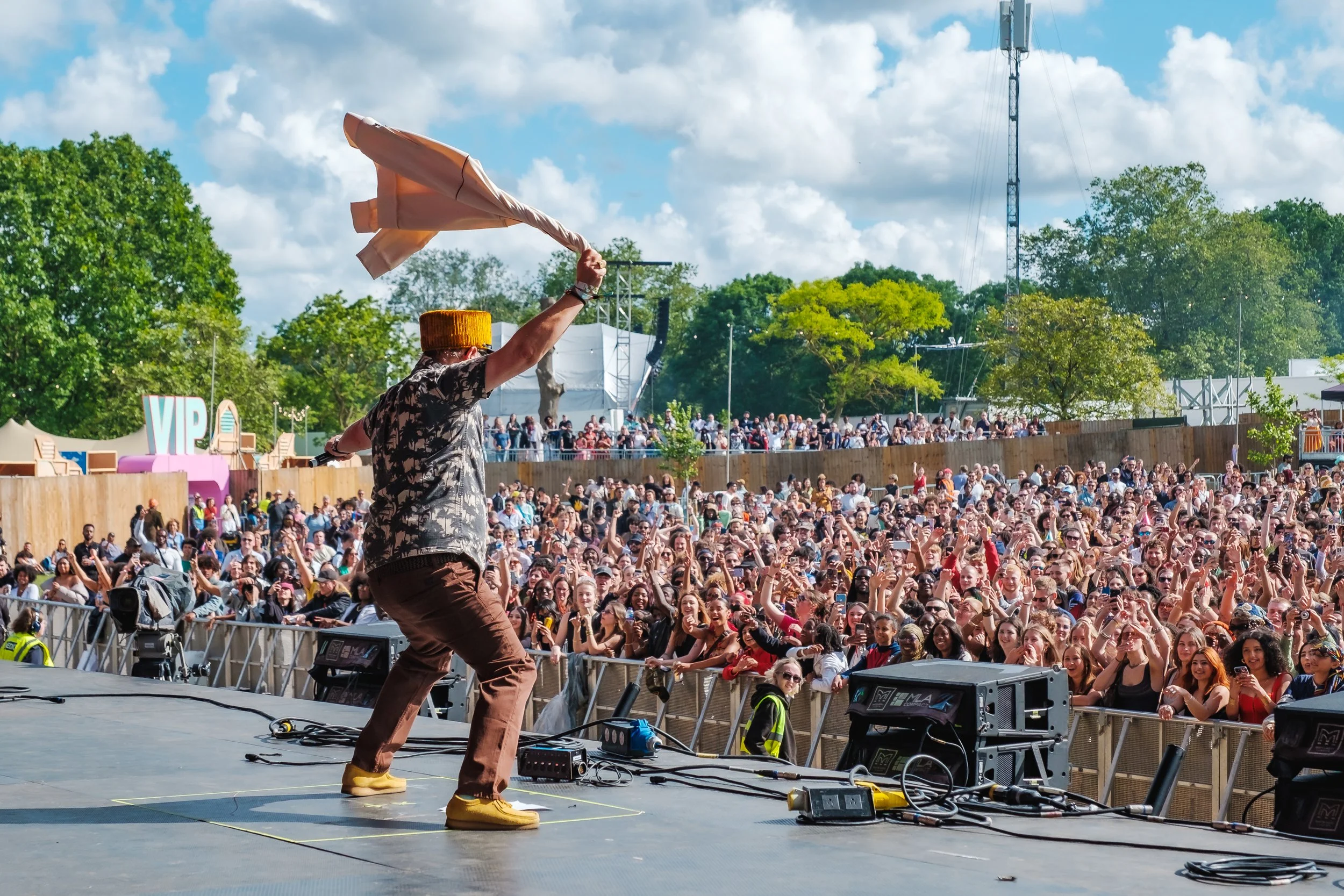Reggae legend David Rodigan waves a shirt while performing on the main stage at Cross The Tracks 2024.