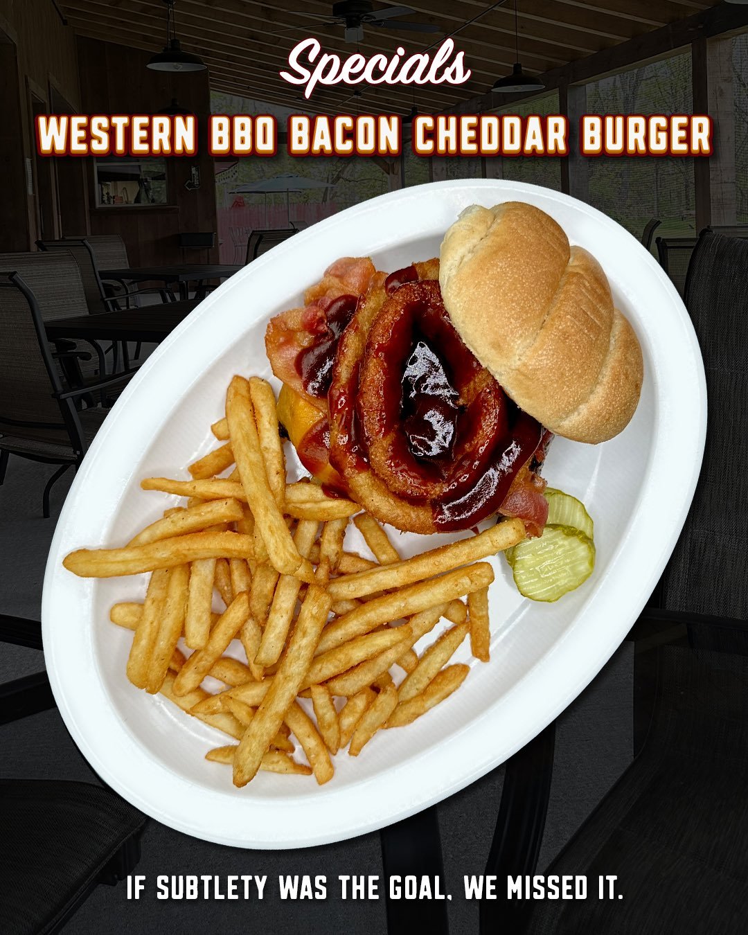 A seasoned burger topped with cheddar cheese, bacon, onion rings, and BBQ sauce on a toasted bun.

Some burgers are built for a quick lunch.

This is not one of those burgers.

This is the kind of burger that requires both hands, at least three napki