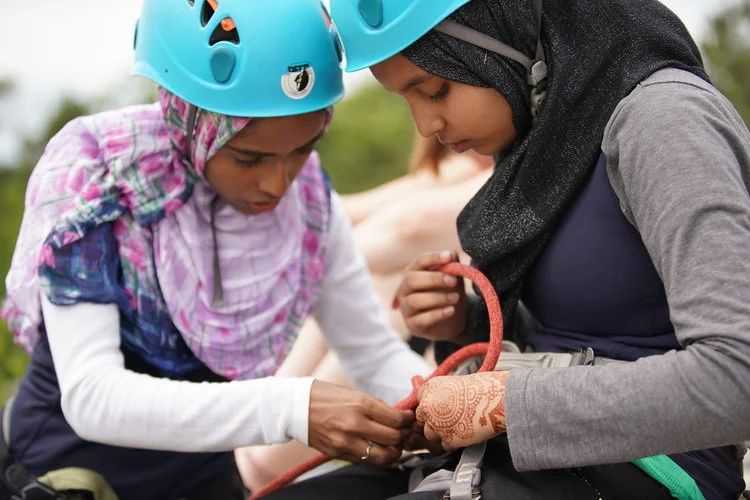 Marjana helps Mharuya with her figure 8 knot. The Gunks, NY Photo by Chris Vultaggio
