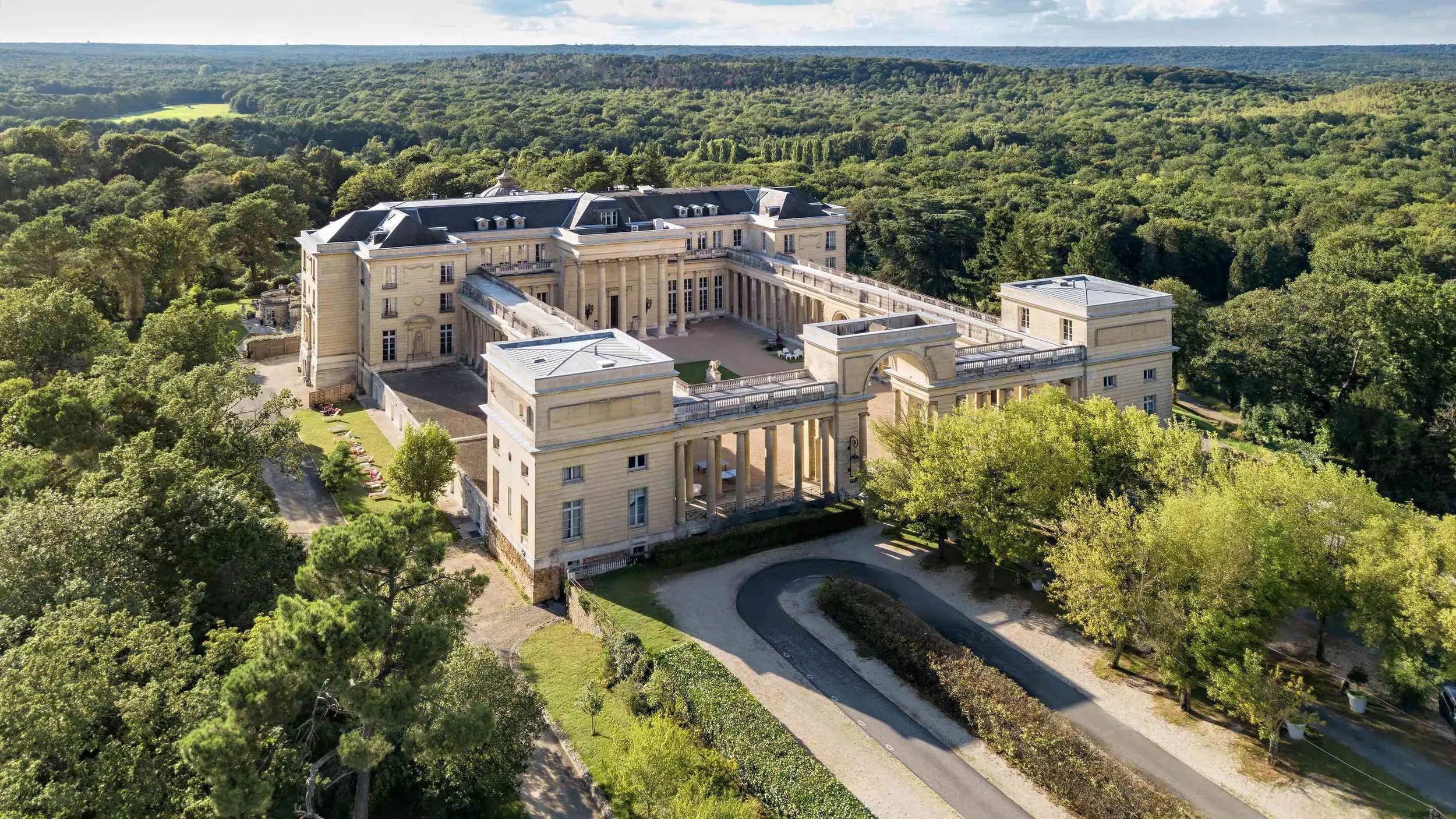 Aerial view of Château Porgès in Rochefort-en-Yvelines surrounded by forest near Paris