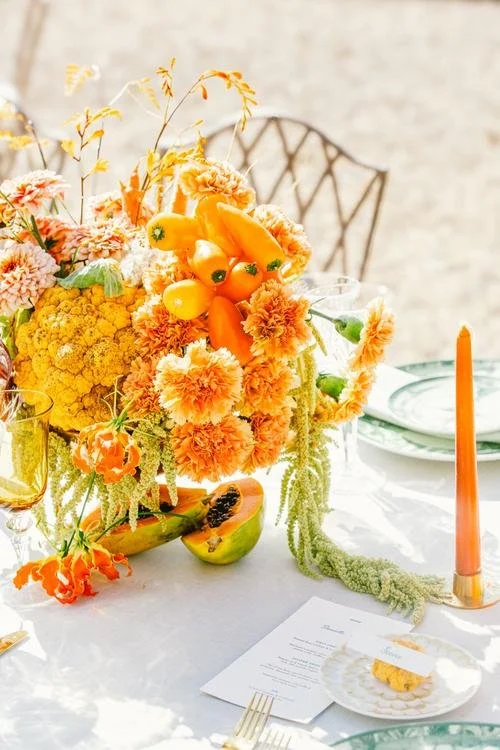 Colorful wedding table with flowers and seasonal vegetables in the gardens of Château de Champlâtreux