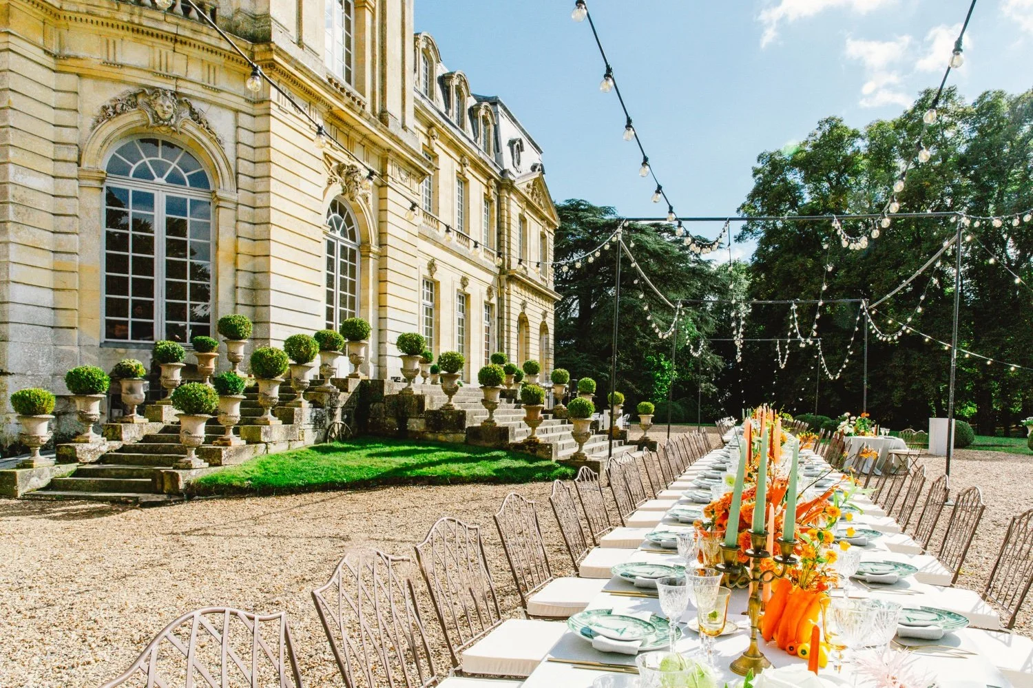 Outdoor wedding reception table in the gardens of Château de Champlâtreux near Paris, France