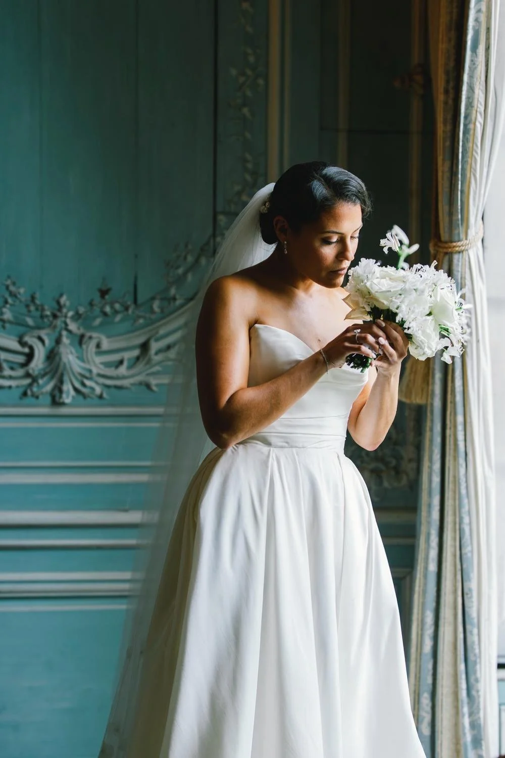 bride portrait by the window inside Château de Champlâtreux near Paris wedding venue