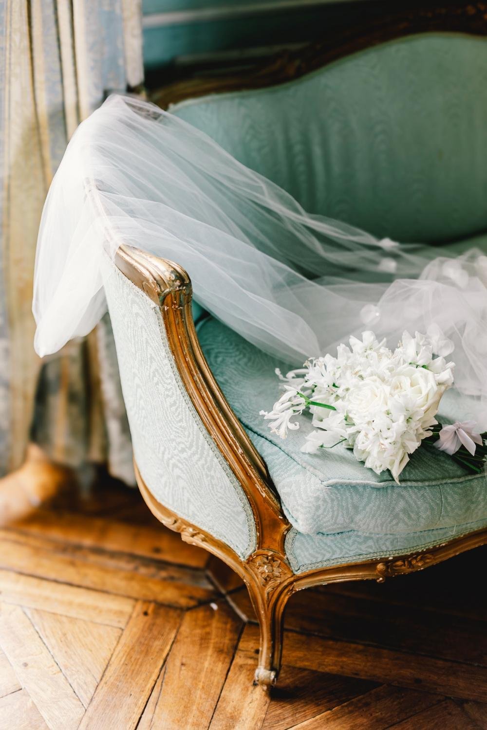 Bridal bouquet and wedding decor details inside Château de Champlâtreux near Paris