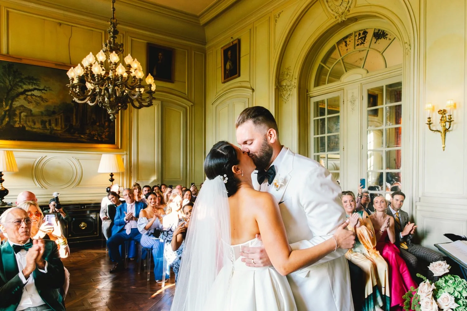 Bride and groom kissing during their wedding ceremony at Château de Champlâtreux near Paris