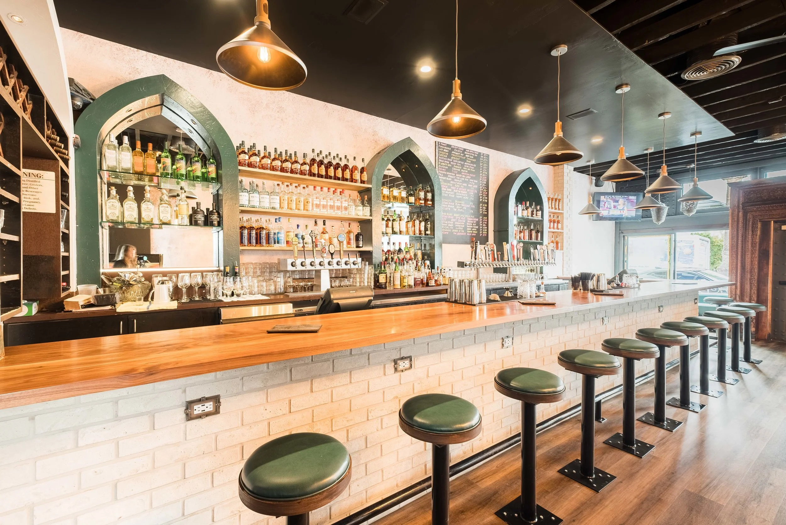 Bar view showing interior with beer taps, sprits and barstool seating