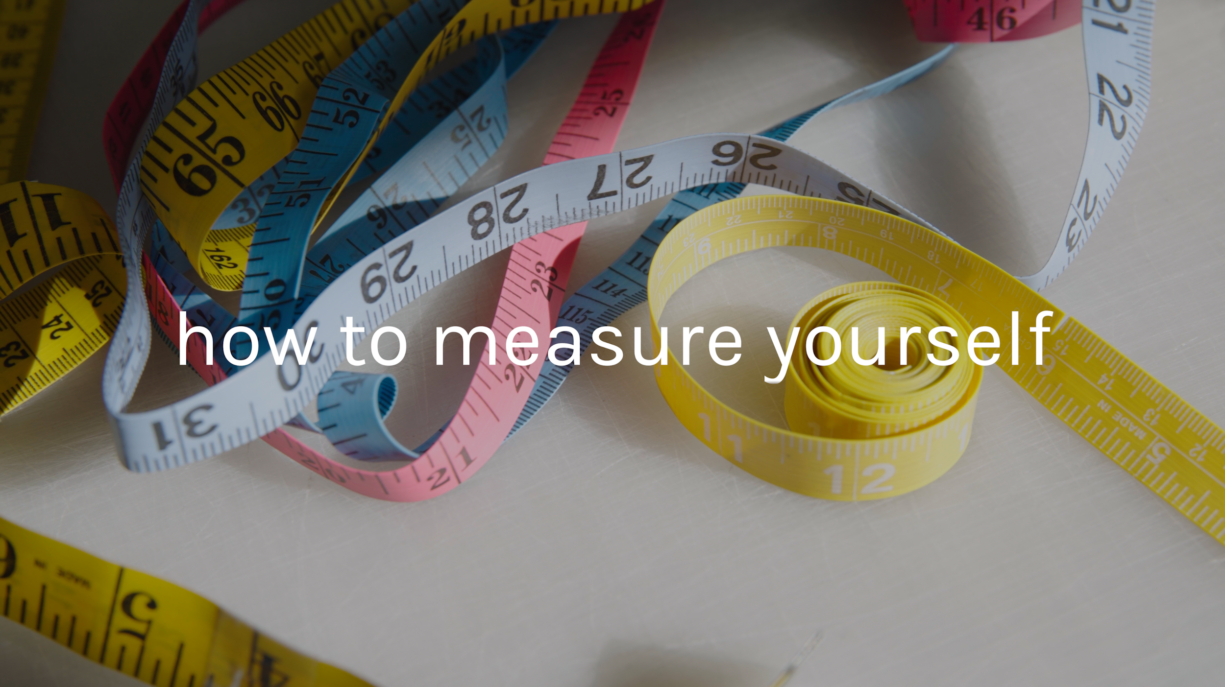 Colorful measuring tapes, including yellow, pink, blue, and white, arranged in a tangled pattern on a light surface with the text 'how to measure yourself' overlayed.