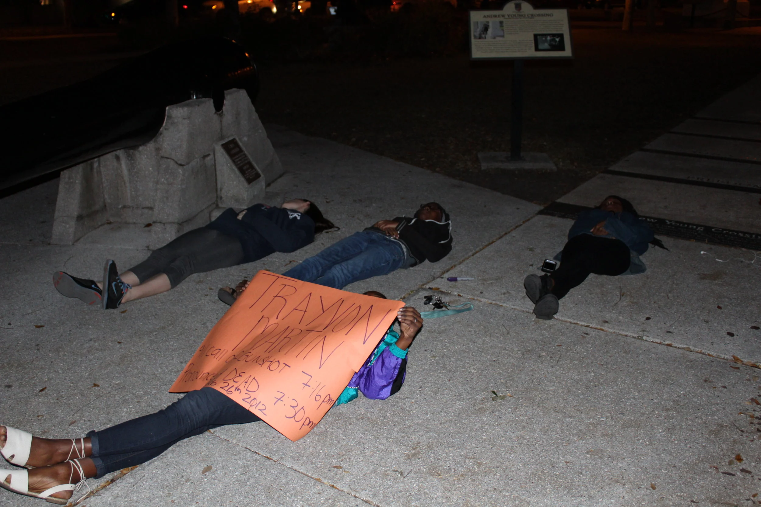 Flagler College students Hasani Malone, Becky Guerrier, Kayla Lloyd and Sam Tate lying on the ground in protest at the Andrew Young crossing in downtown St. Augustine to protest on the anniversary of Trayvon Martin’s death.