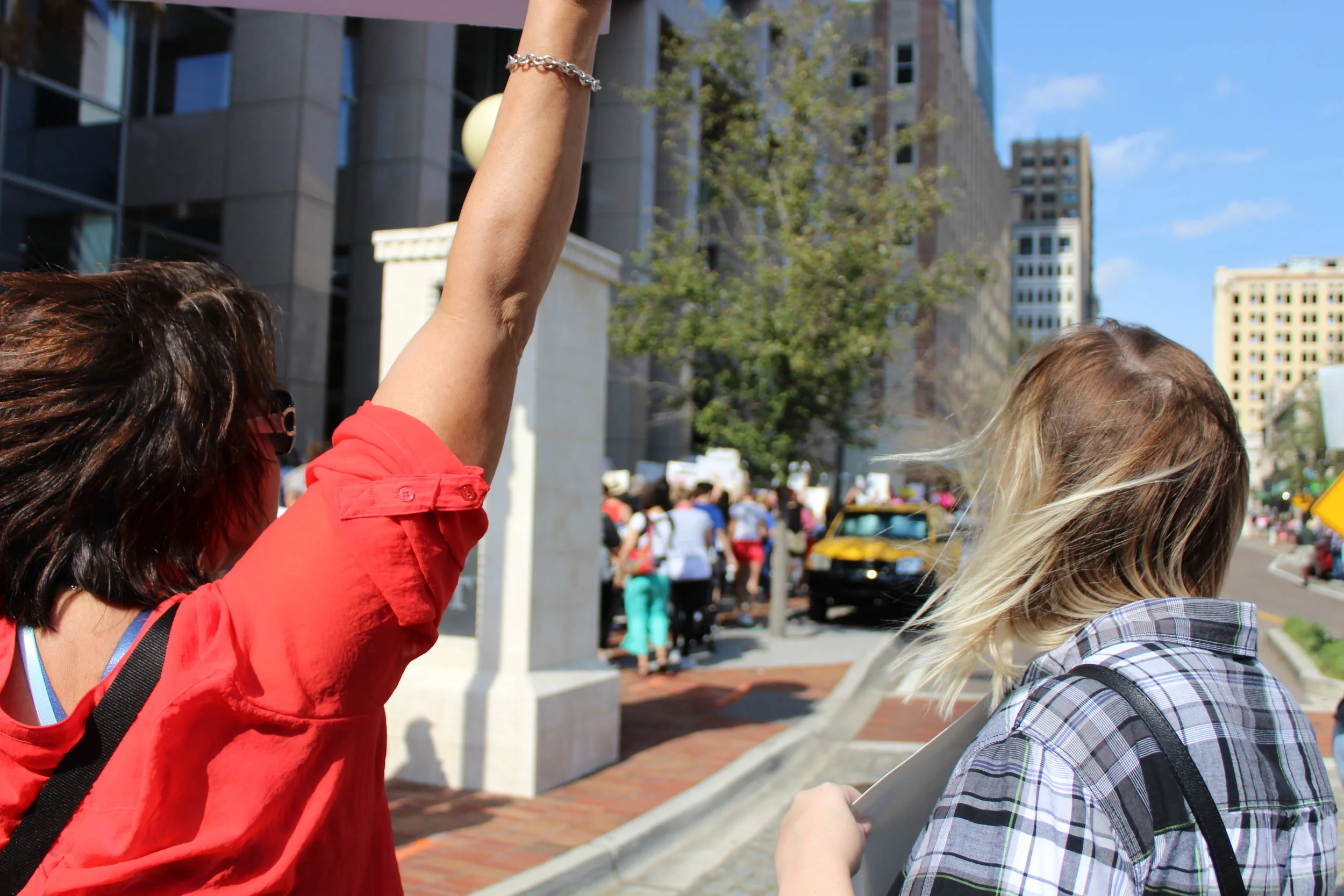 Two women begin the march towards city hall while organizers warn people to stay on the sidewalks or they will be arrested.