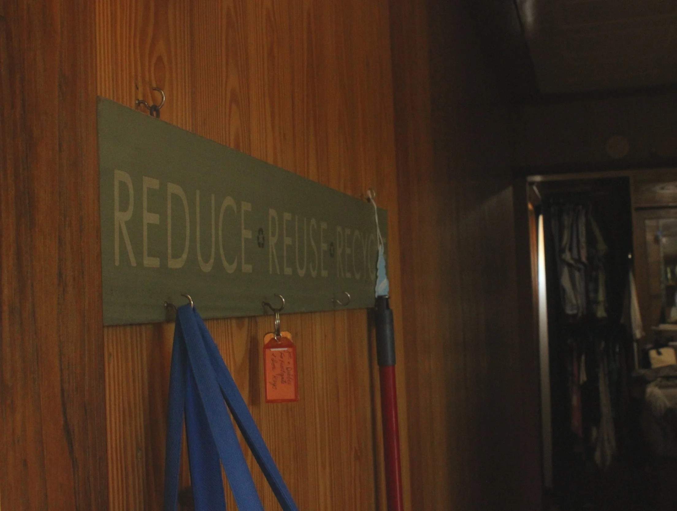 A bag holder at the entrance to the Moreley home that reads “reduce, reuse, recycle.”