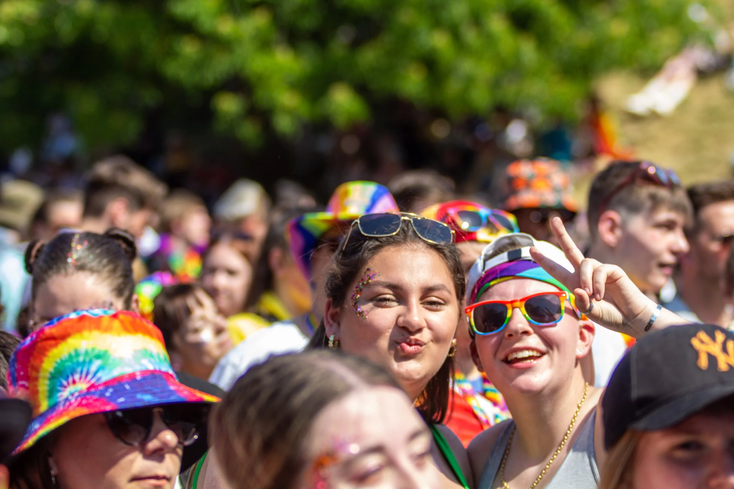 Photo of two people smiling at the camera within the crowds of Pride Canterbury.