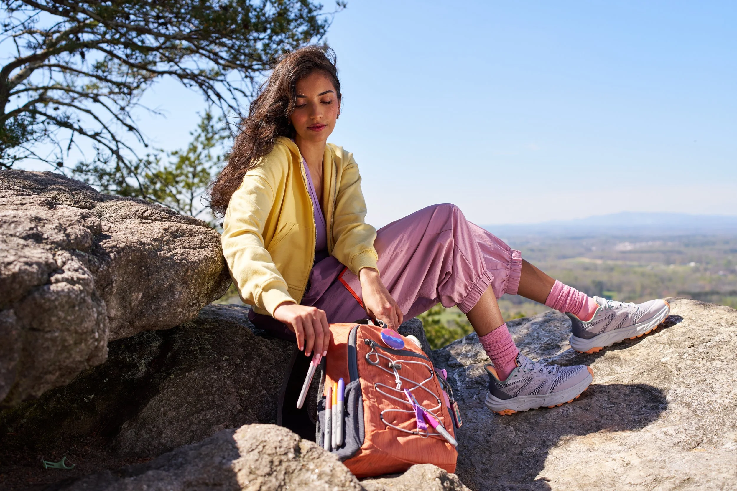 sharpie pens bold horizons woman reaching to backback grabbing pink sharpie on mountain