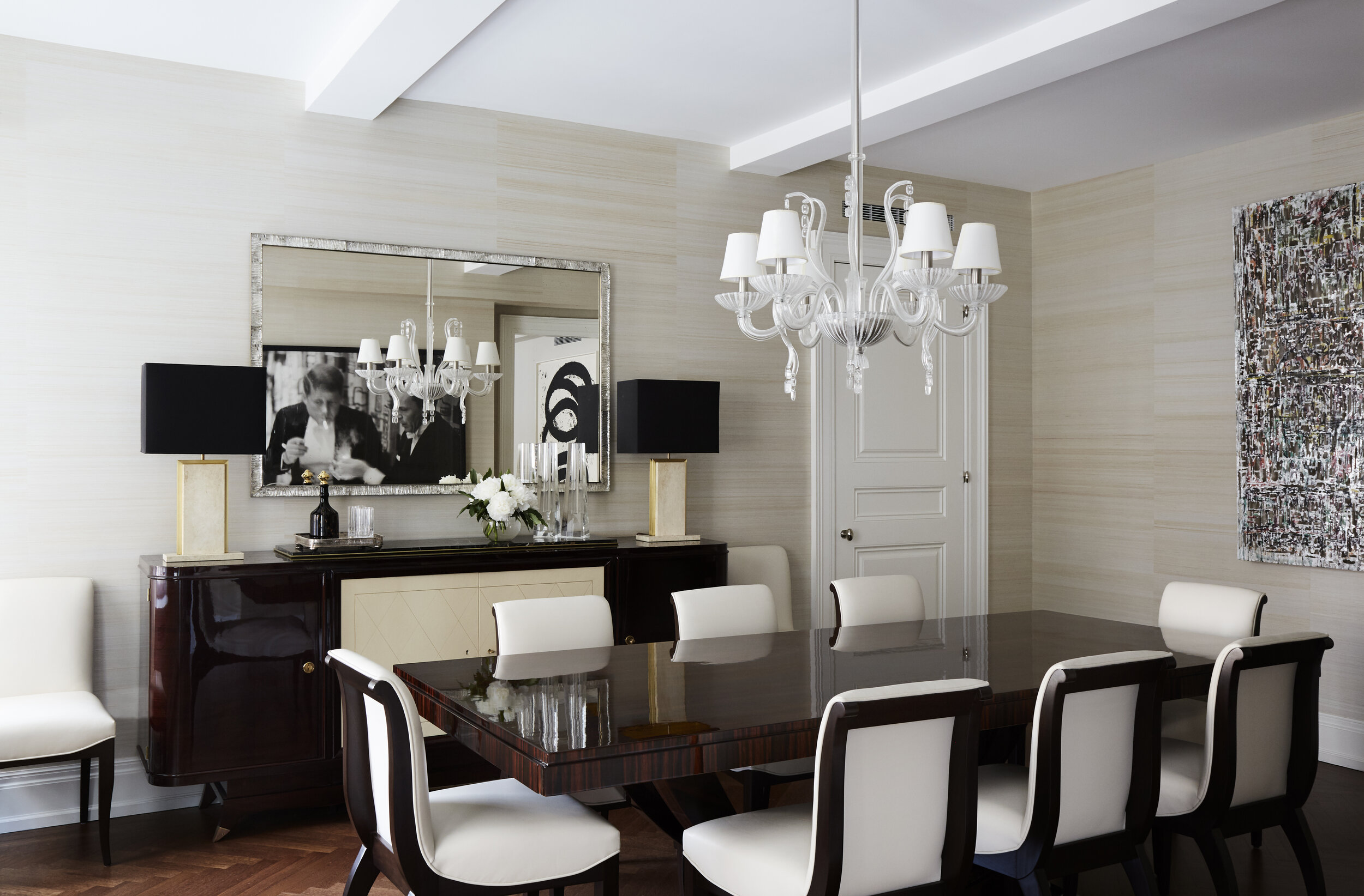 formal dining room with white and wood dining chairs, large mirror with glass chandelier