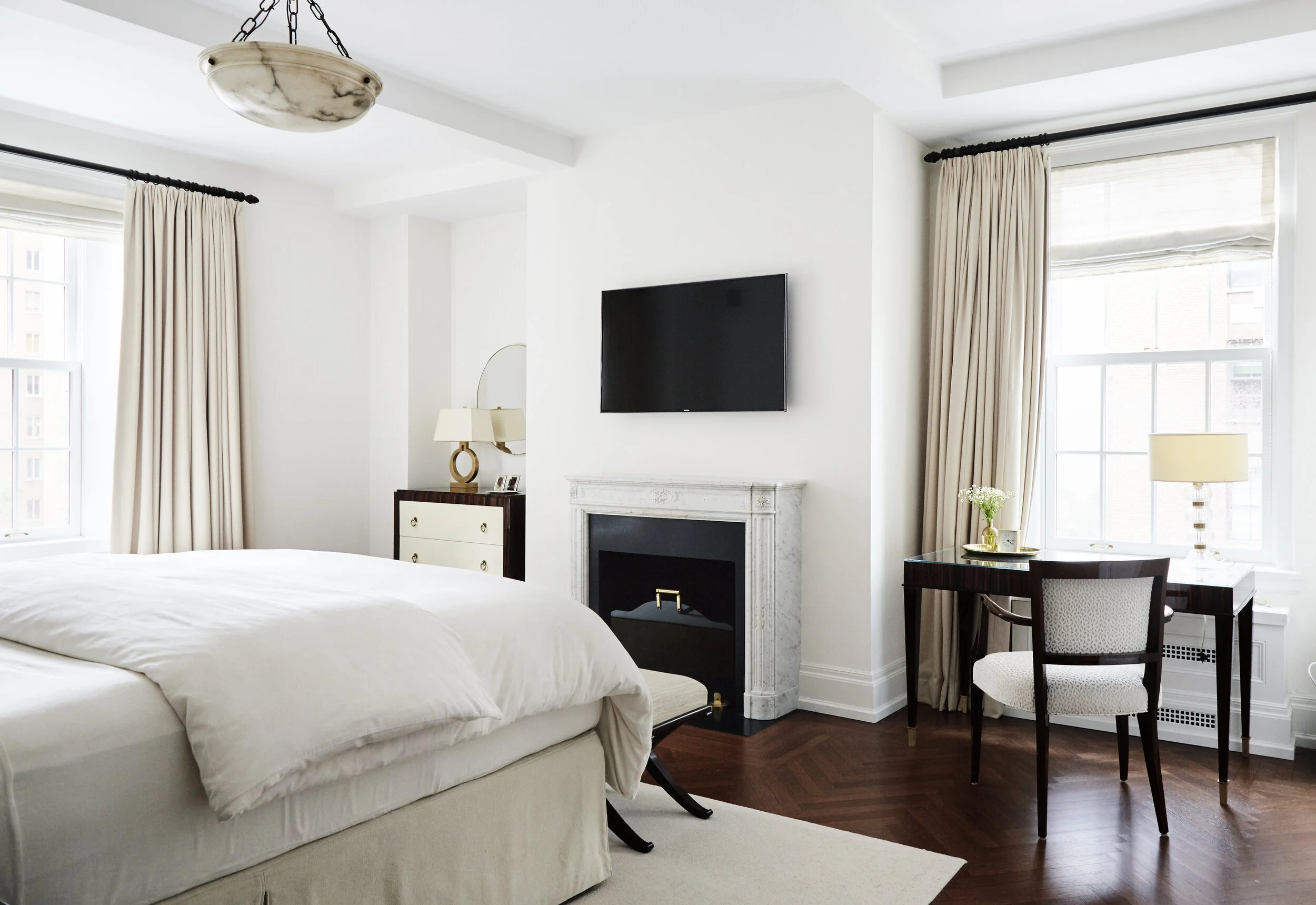 Primary suite with white walls, white marble mantel and dark wood desk