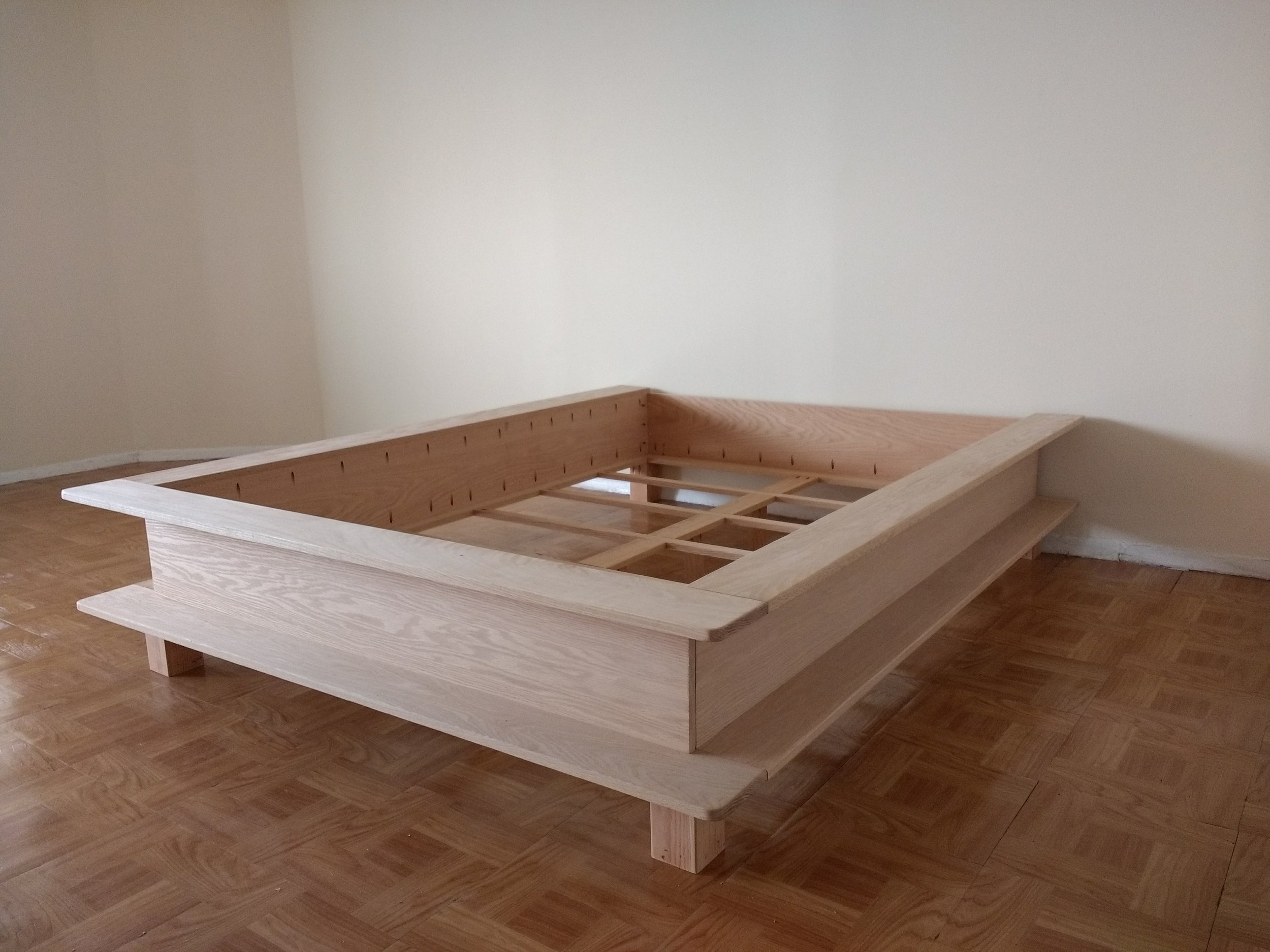 Multifunctional Bed Brooklyn, NY | 2017 Red Oak. 18 x 63 x 85 inches The bed is designed with its height as a seating area for a studio apartment, and its sides as a bookshelf. The upper surfaces can be used as a linear night table. The four functions collapsed into one object is a response to the ever rising costs of urban interior space that push its city dwellers to lead compact and contained life styles.