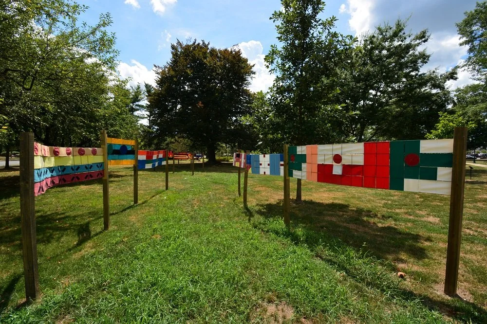   Between Flagships     2022 7 feet high x 90 x 90 feet area covered  Fabrics, steel wire mesh, paint, wood    Summit Public Art. Summit City, New Jersey    From Summit City demographic data, I chose colors, shapes, and patterns from twenty national 