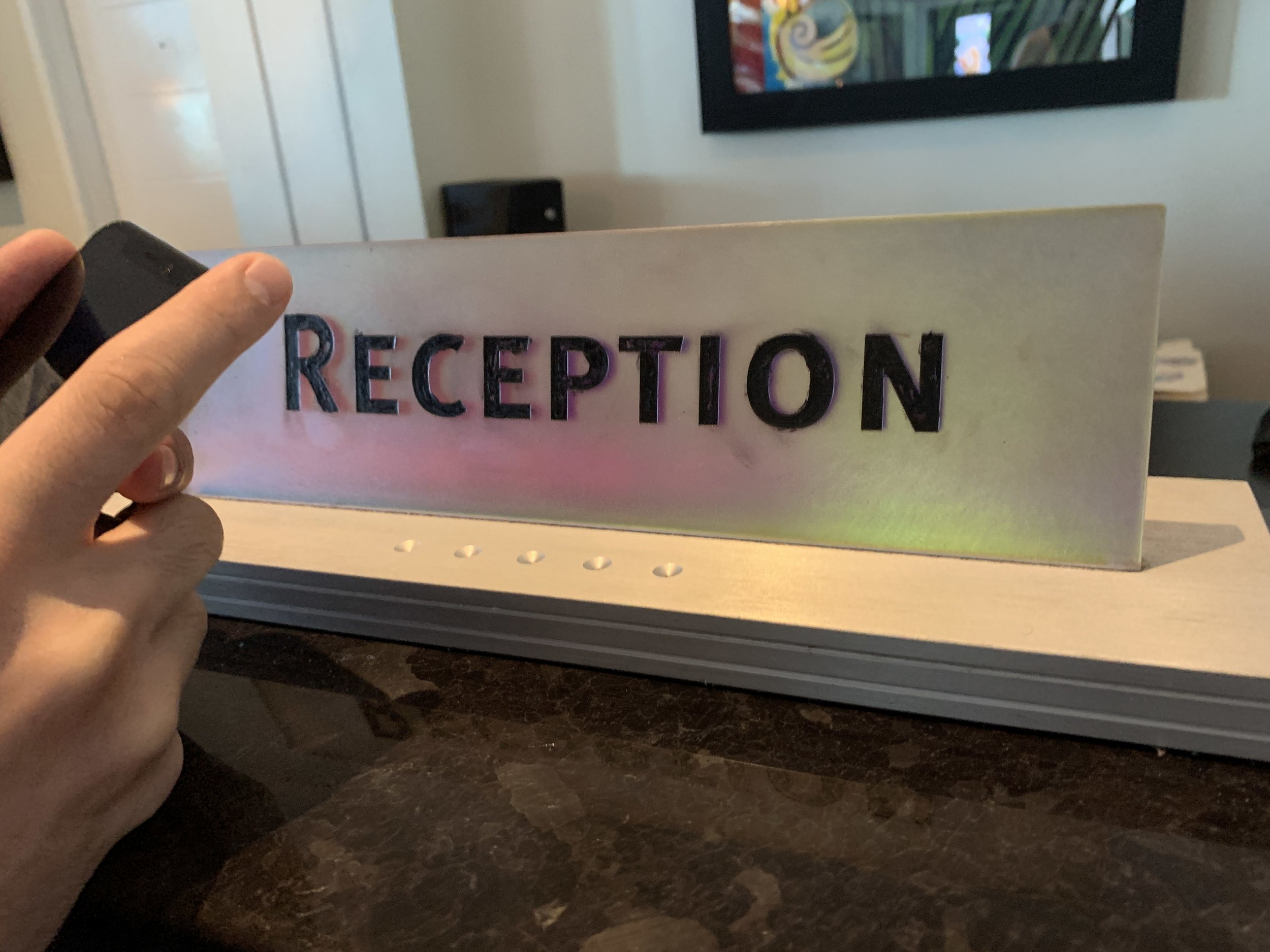 Close up of the Reception Desk sign. It looks like it was colored in with a ball point pen