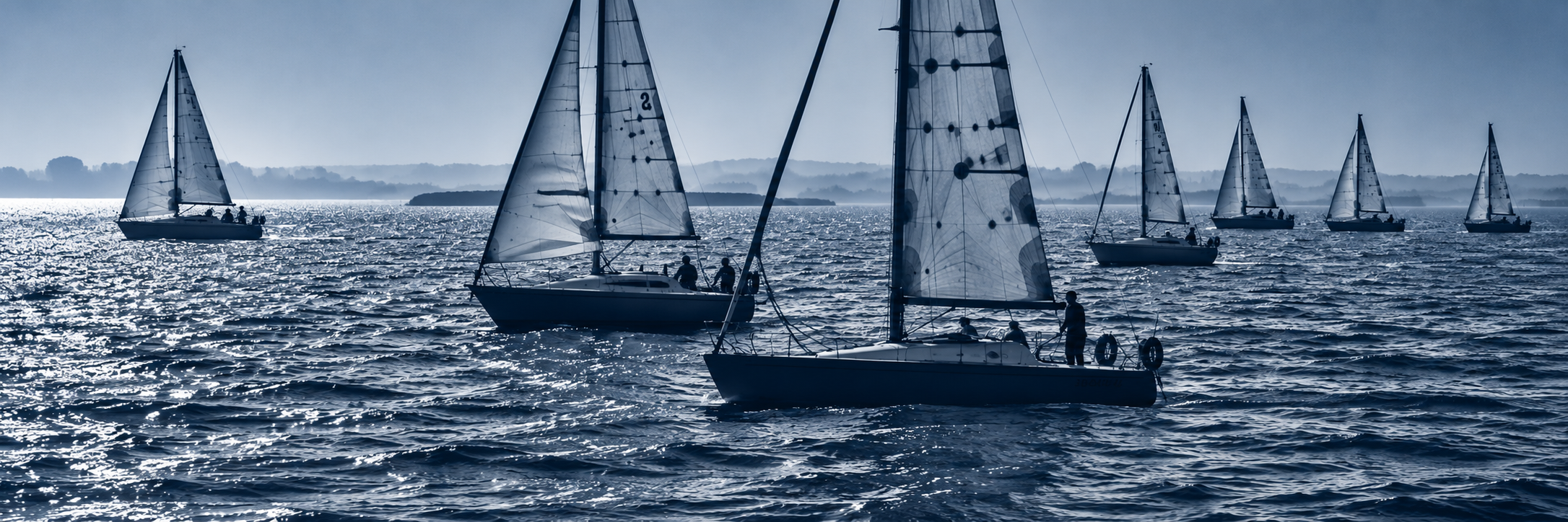 Blue-Tinted Sailboat Regatta at Sea.png