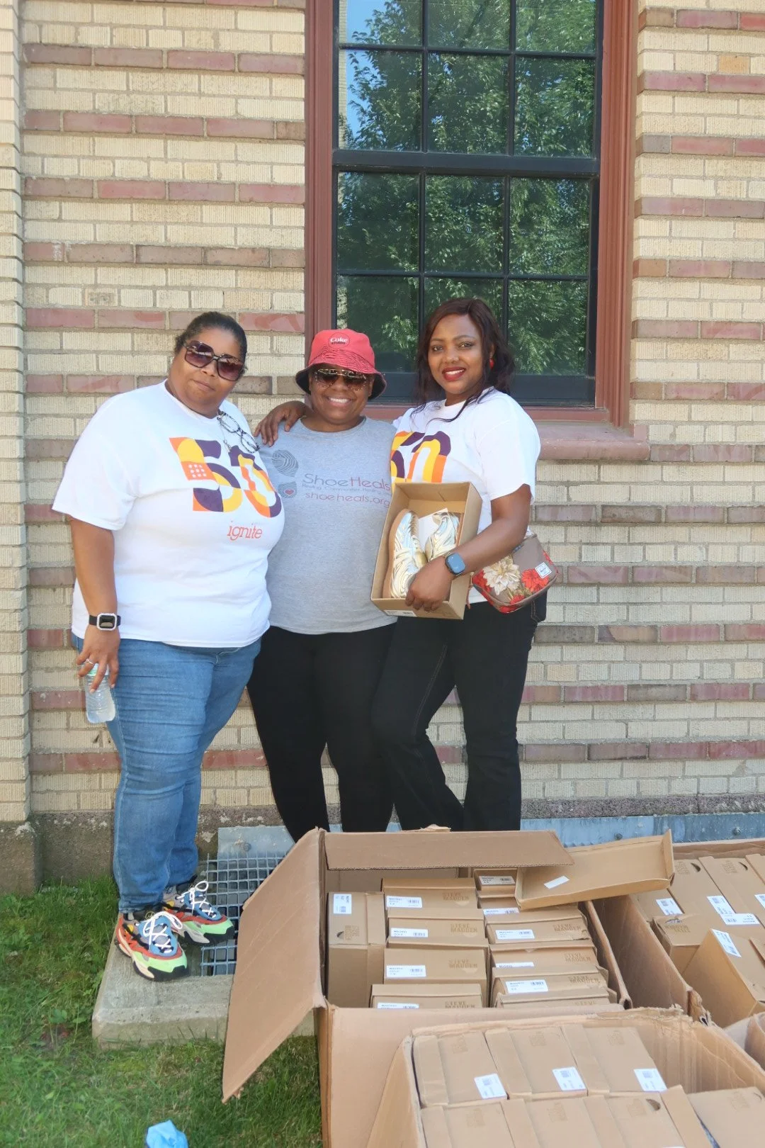 Ignite staff is pictured with ShoeHeals CEO giving out free shoes to attendees of the Ignite Back-to-School Carnival.