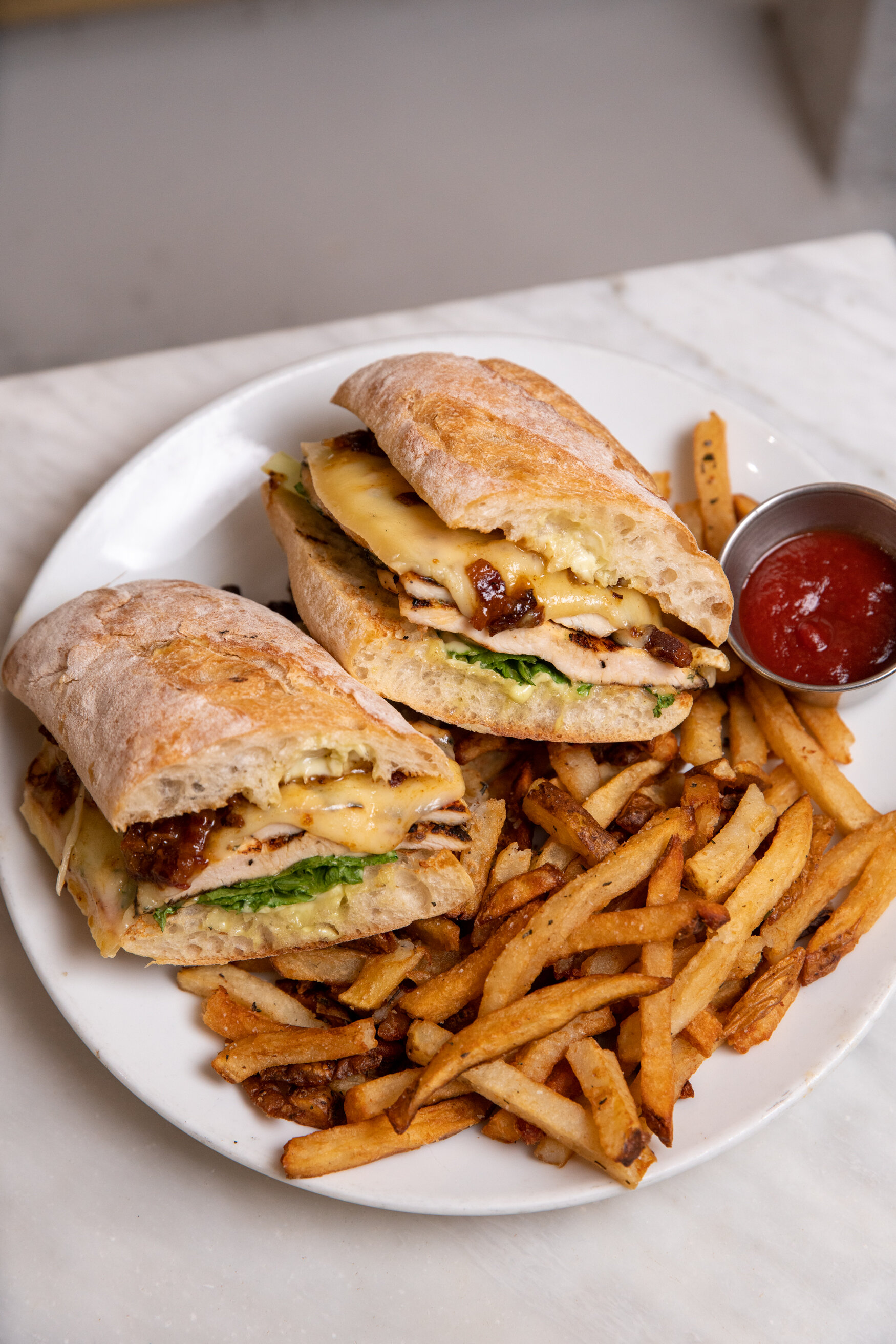 chicken and swiss sandwich on a plate with french fries 