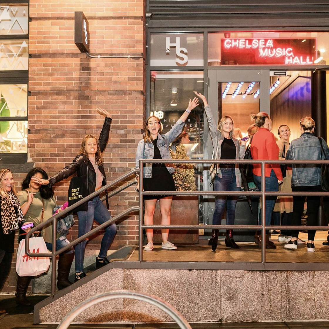 people waiting in line outside against a brick building 