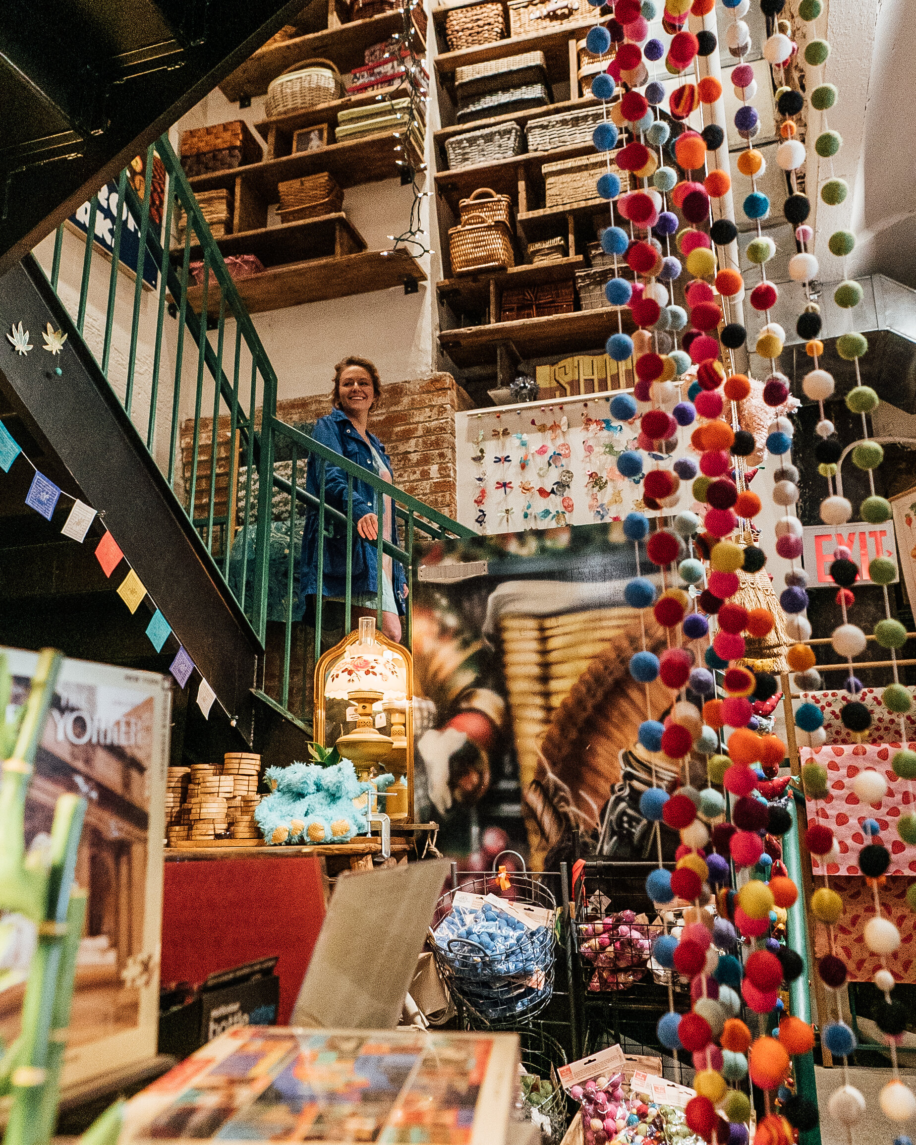 woman walking down stairs, baskets lining shelves, pompoms in for-front 