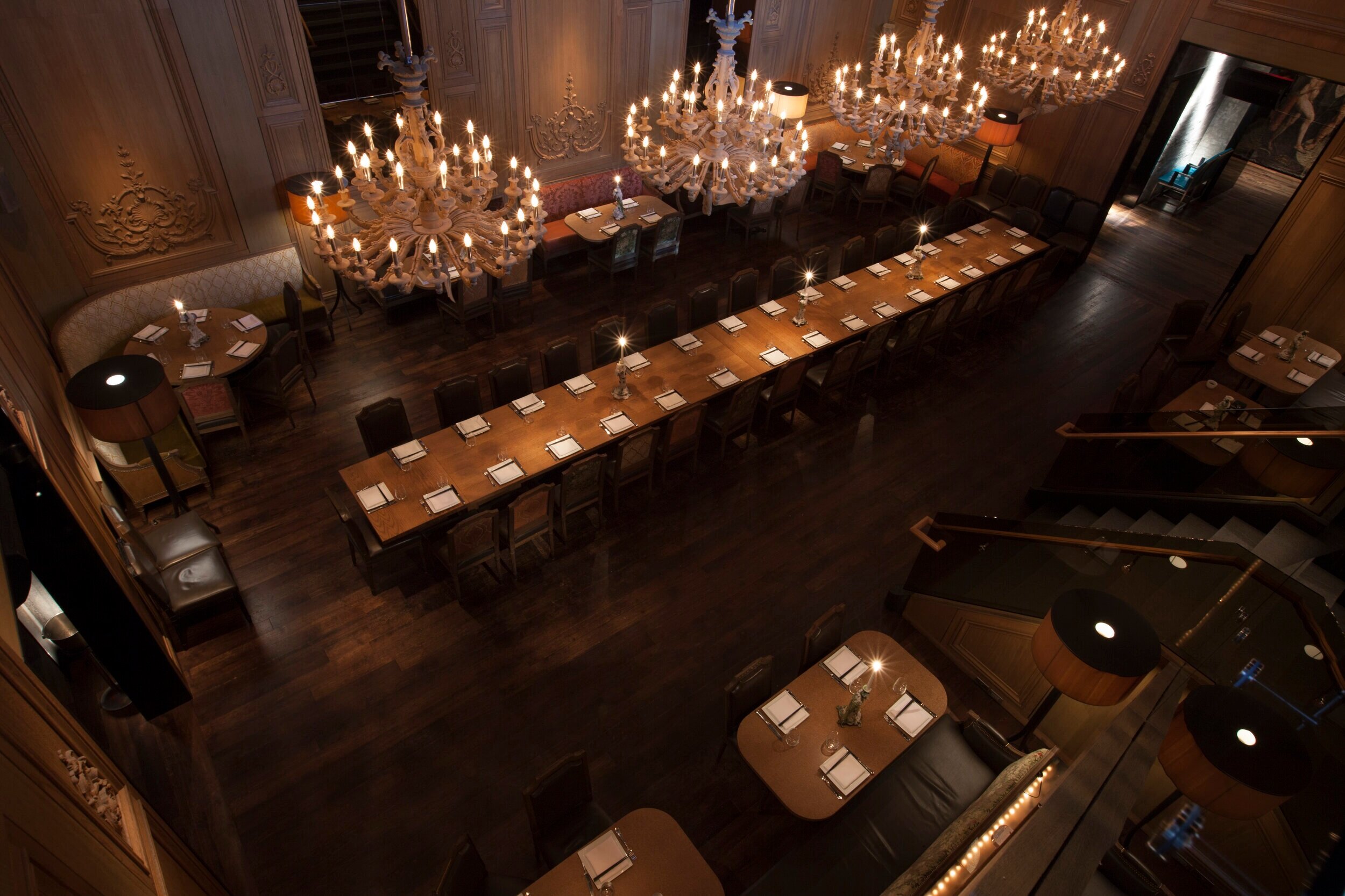 overhead interior shot of buddakan.   long wooden table with wooden chandeliers hanging with lights