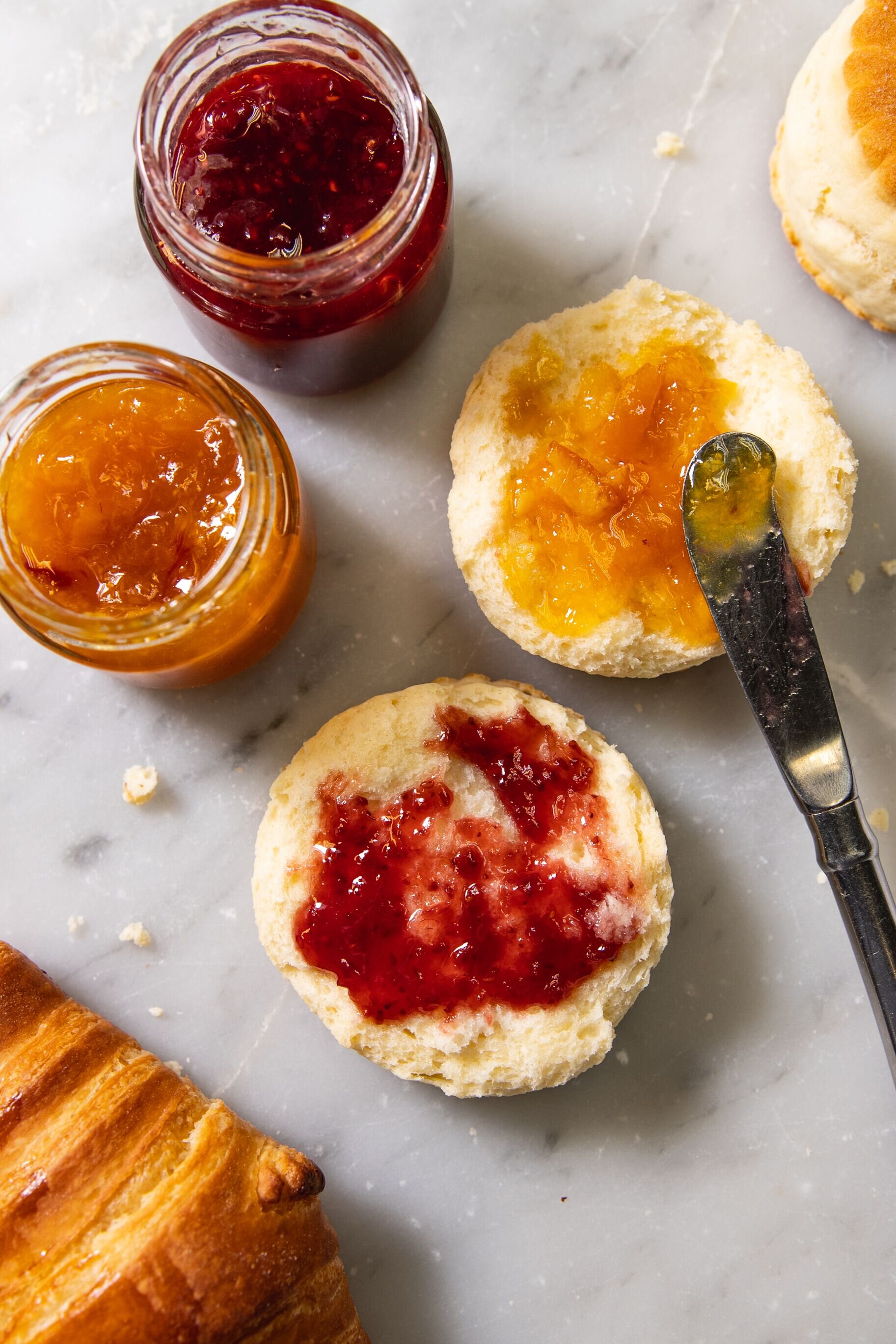 english muffin cut open with a different type of jams on each 