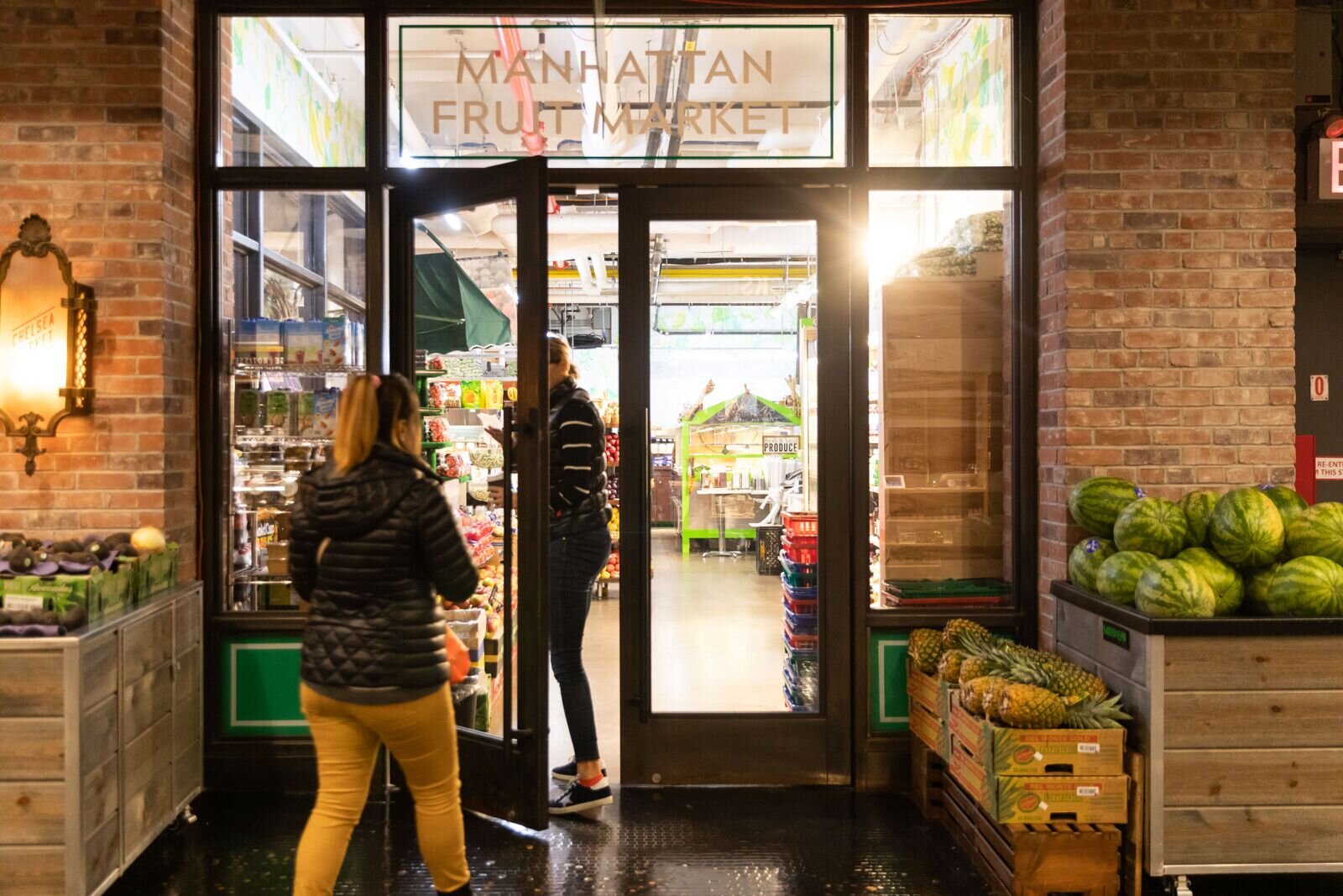 interior entrance to Manhattan Fruit Market with people walking through the doors 