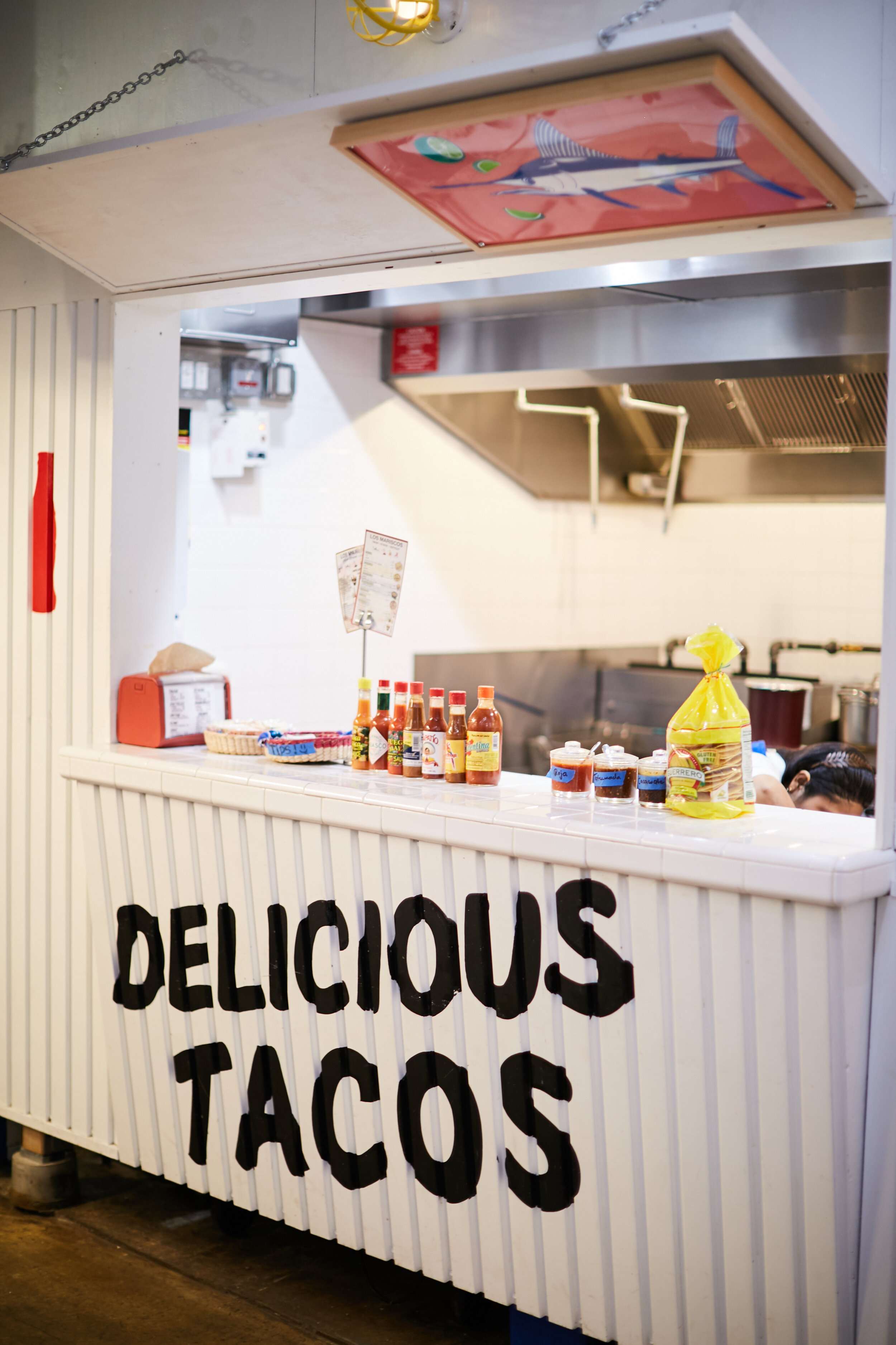 bar reading delicious tacos with window into kitchen 