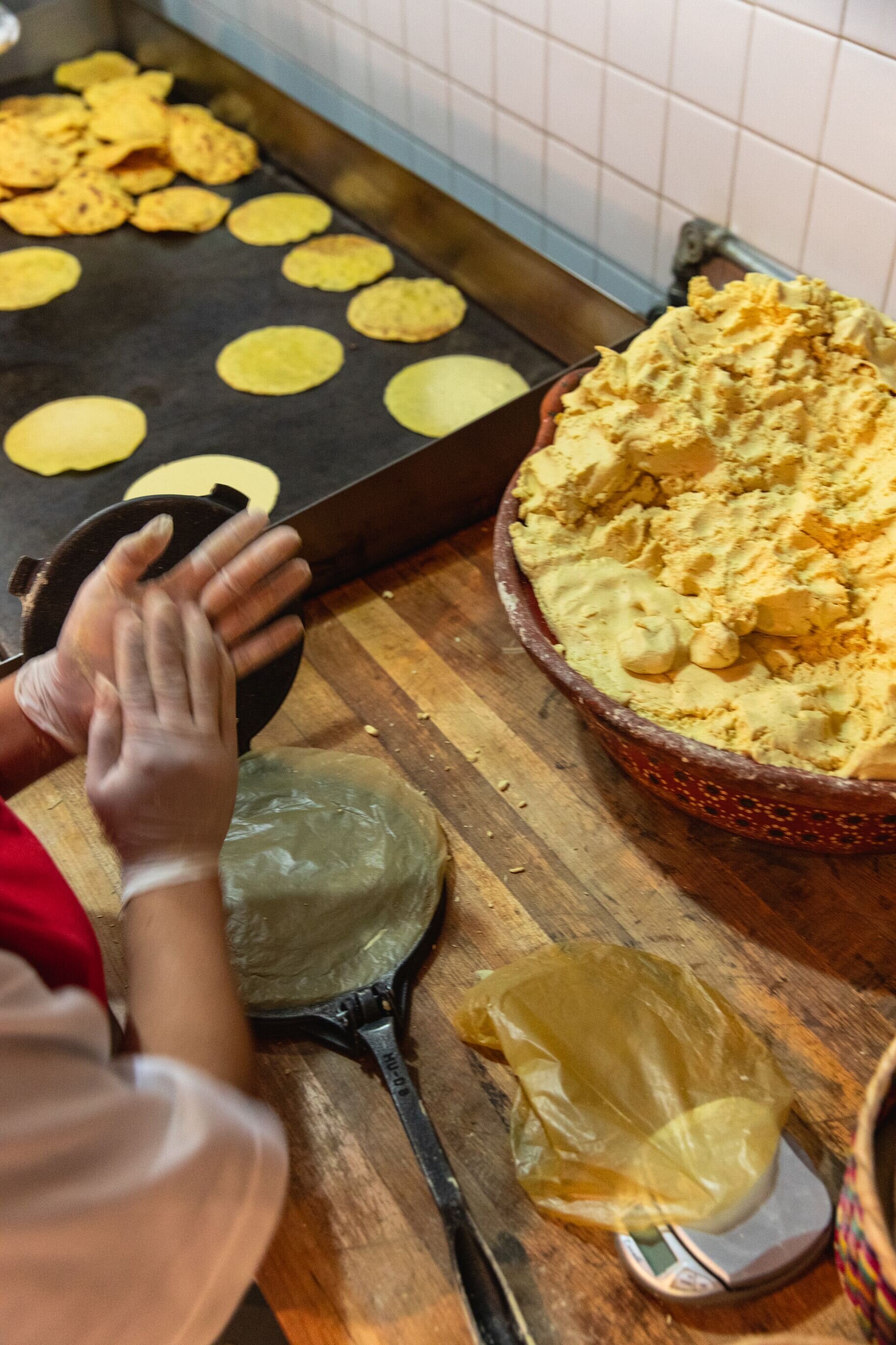 corn tortillas being hand pressed