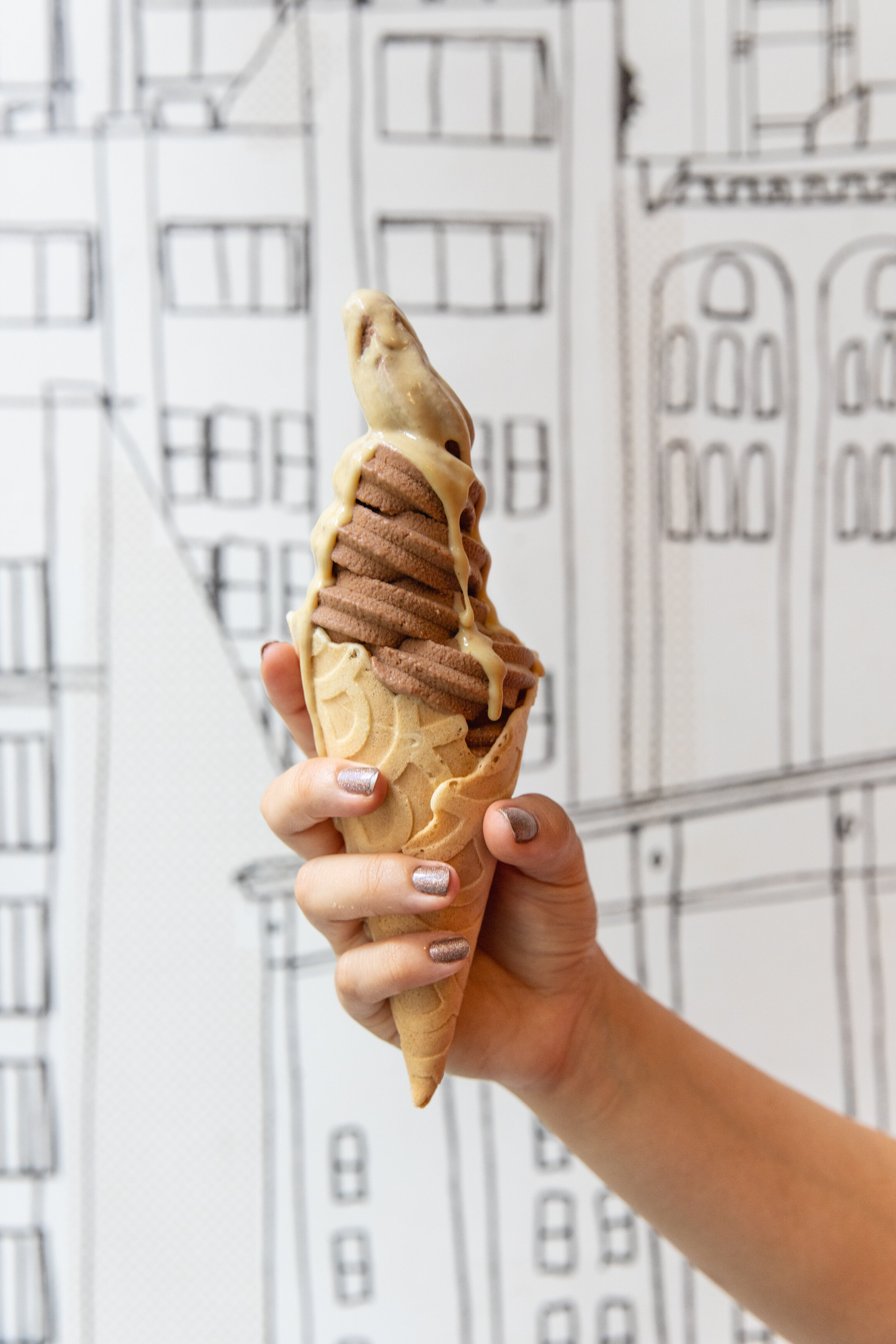 ice cream cone with chocolate soft serve and tahini on top