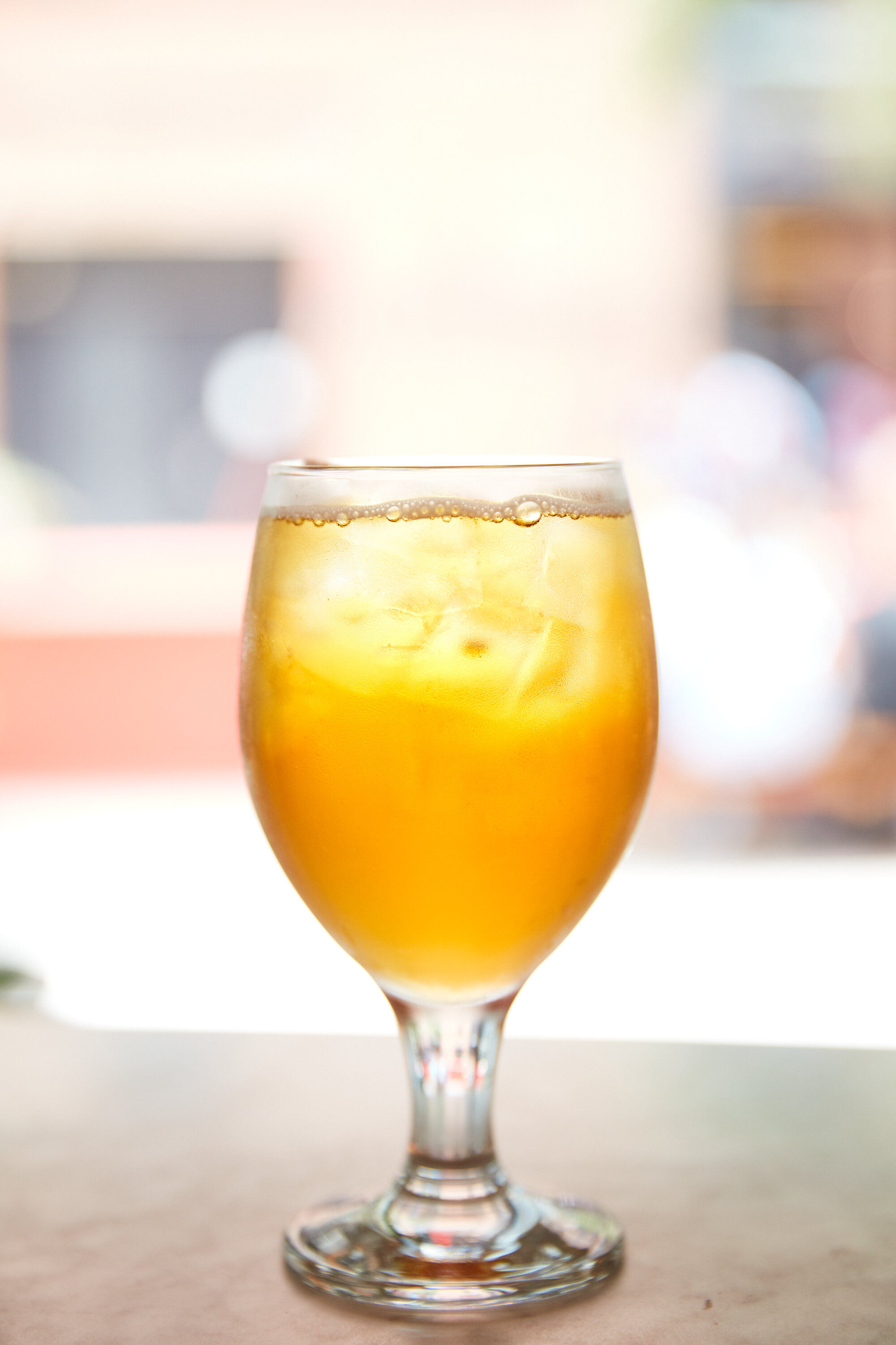  Yellow tea in a glass with ice sits on a bar 