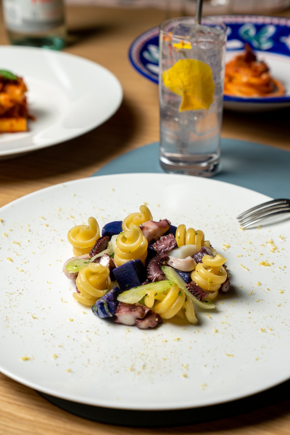 spiral pasta with squid, apple slices, and purple potatos