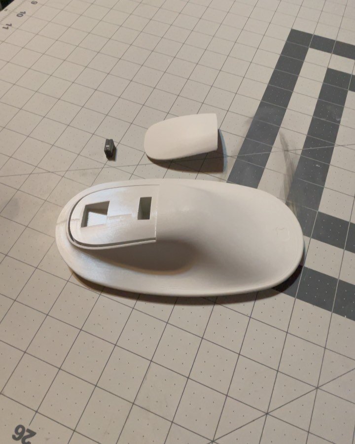 After tearing down the Apple Magic mouse, I removed the tact switch/mouse clicking element to allow me to create a more functional prototype. 

Here I kept the assembly geometry stupid simple to try to reduce the risk of printing distortion and suppo