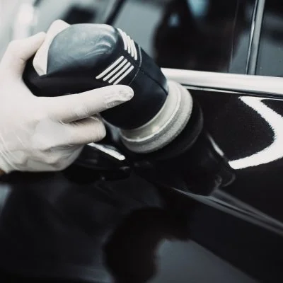 Machine applying protective wax to a glossy boat surface
