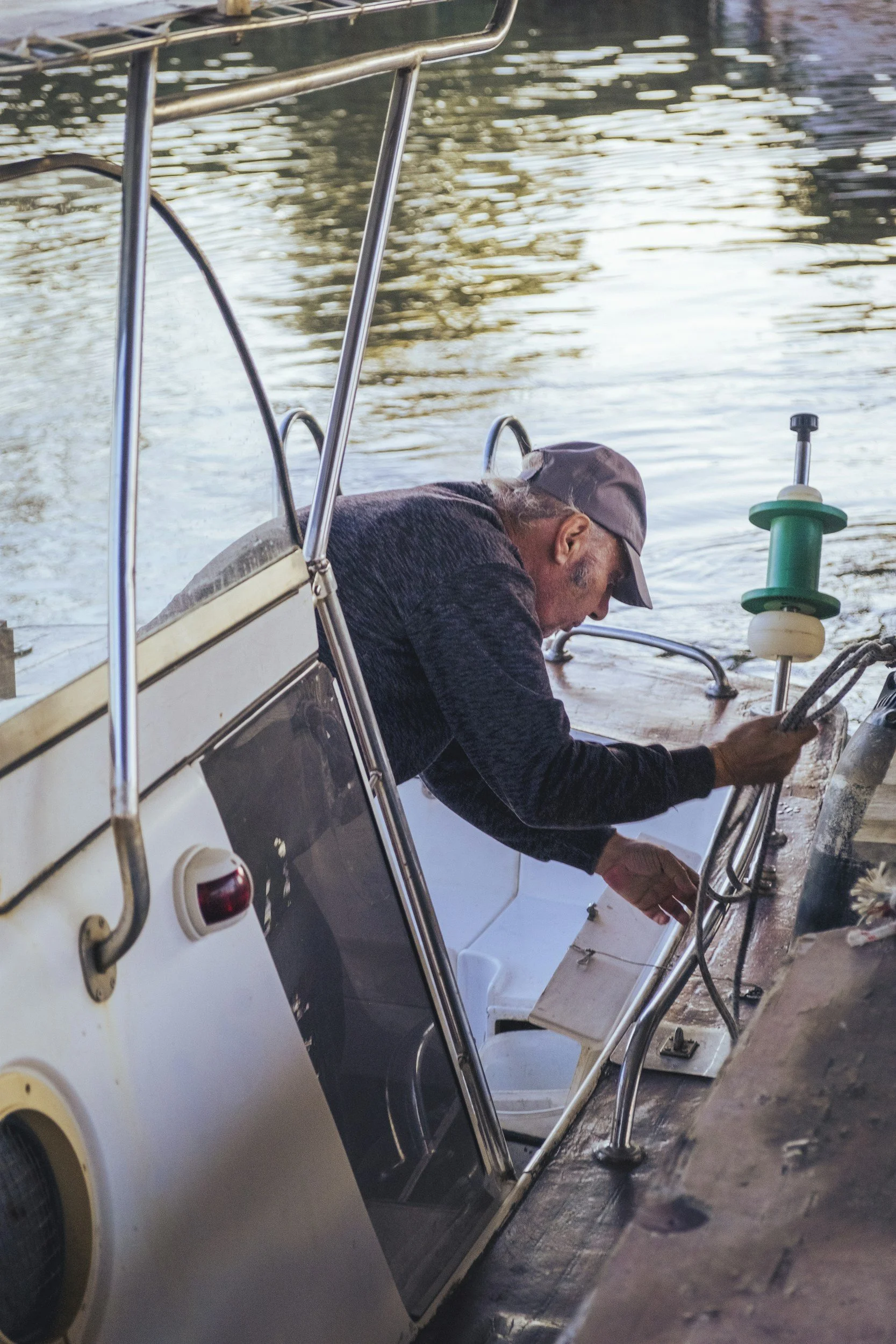 Boat detailor working on a boat at a marina dock