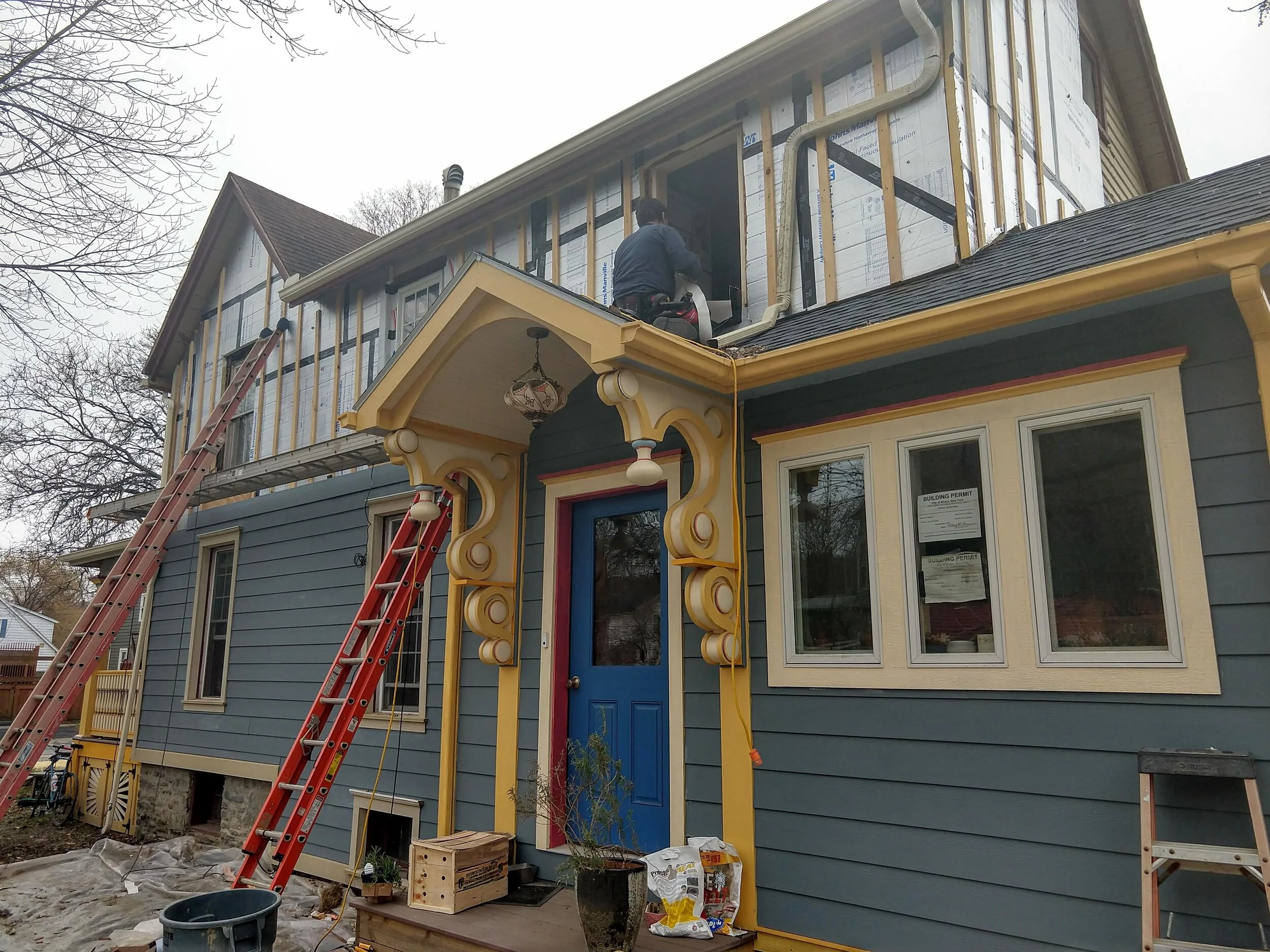 Installing foam board insulation on an existing home when replacing the siding. Taping the insulation seams provides an air barrier as well. (Photo: Karim Beers)