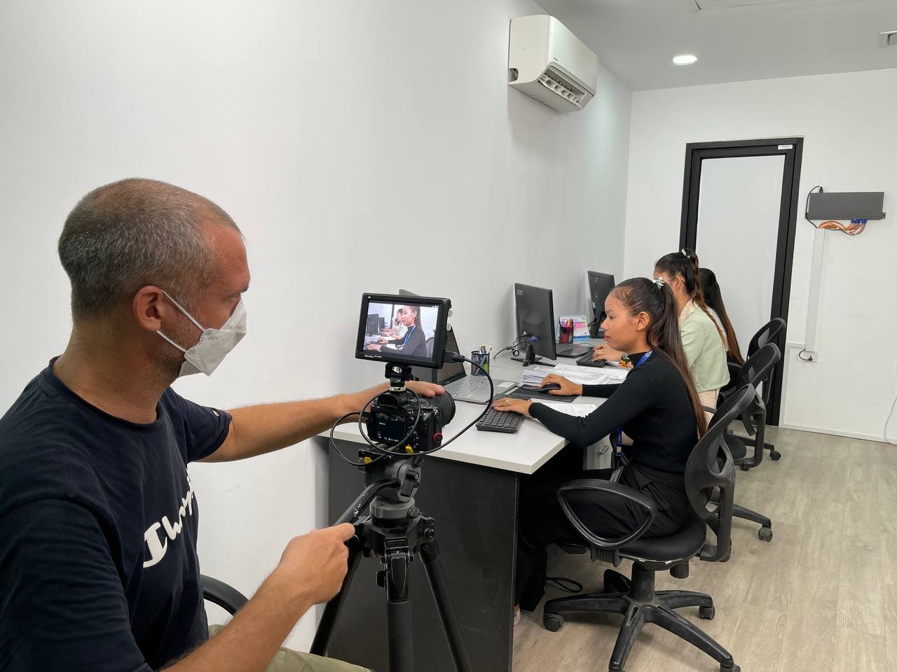 Filming an image of a BECL worker analyzing data on a computer