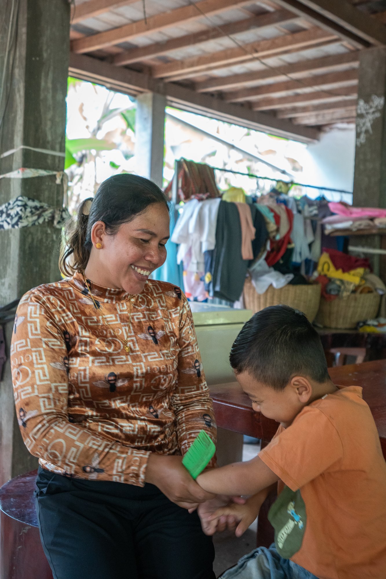 Nil Thach brushes her sons hair