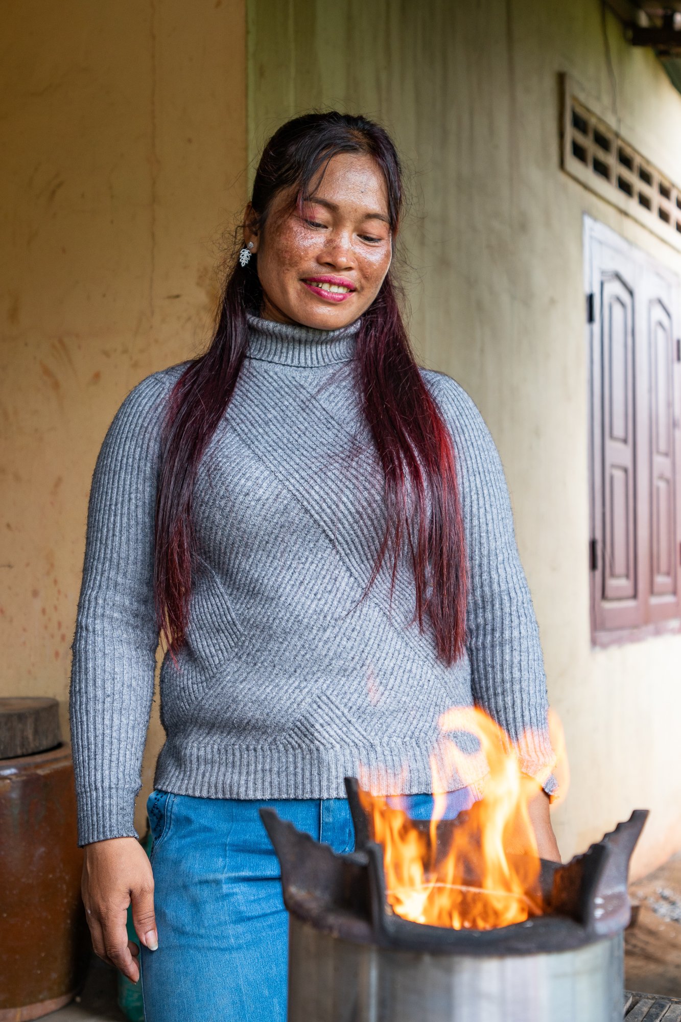 Seap Rain looking at her ACE cooking stove bought using a loan from the NGO Kiva, Siem Reap, Cambodia