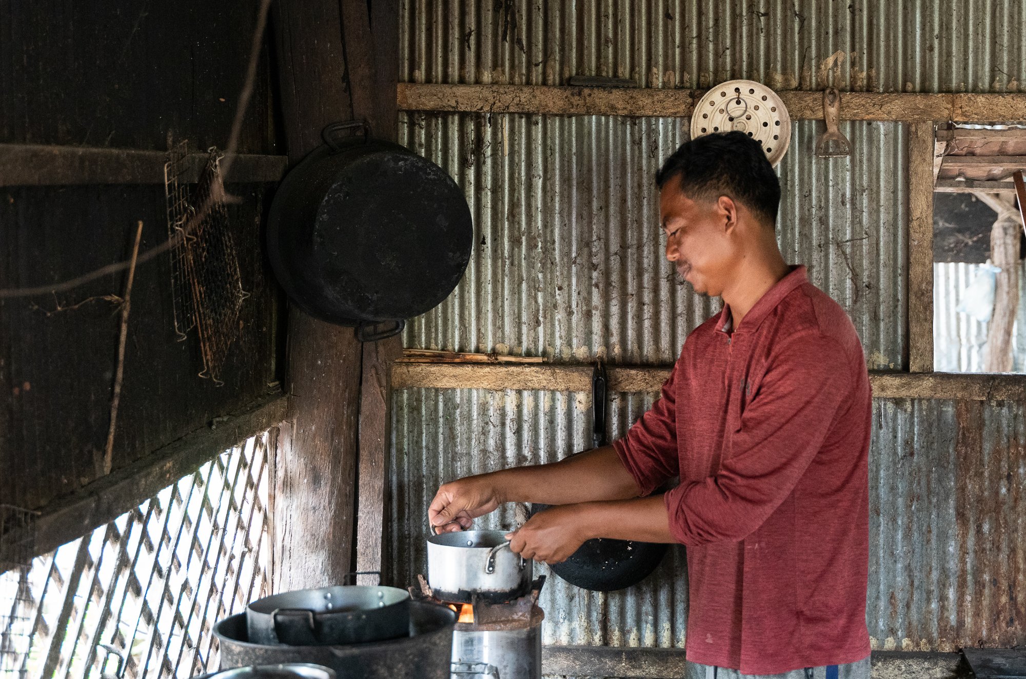 Heng Vichet cooks using his ACE stove he bought using a loan from the NGO Kiva, Siem Reap, Cambodia