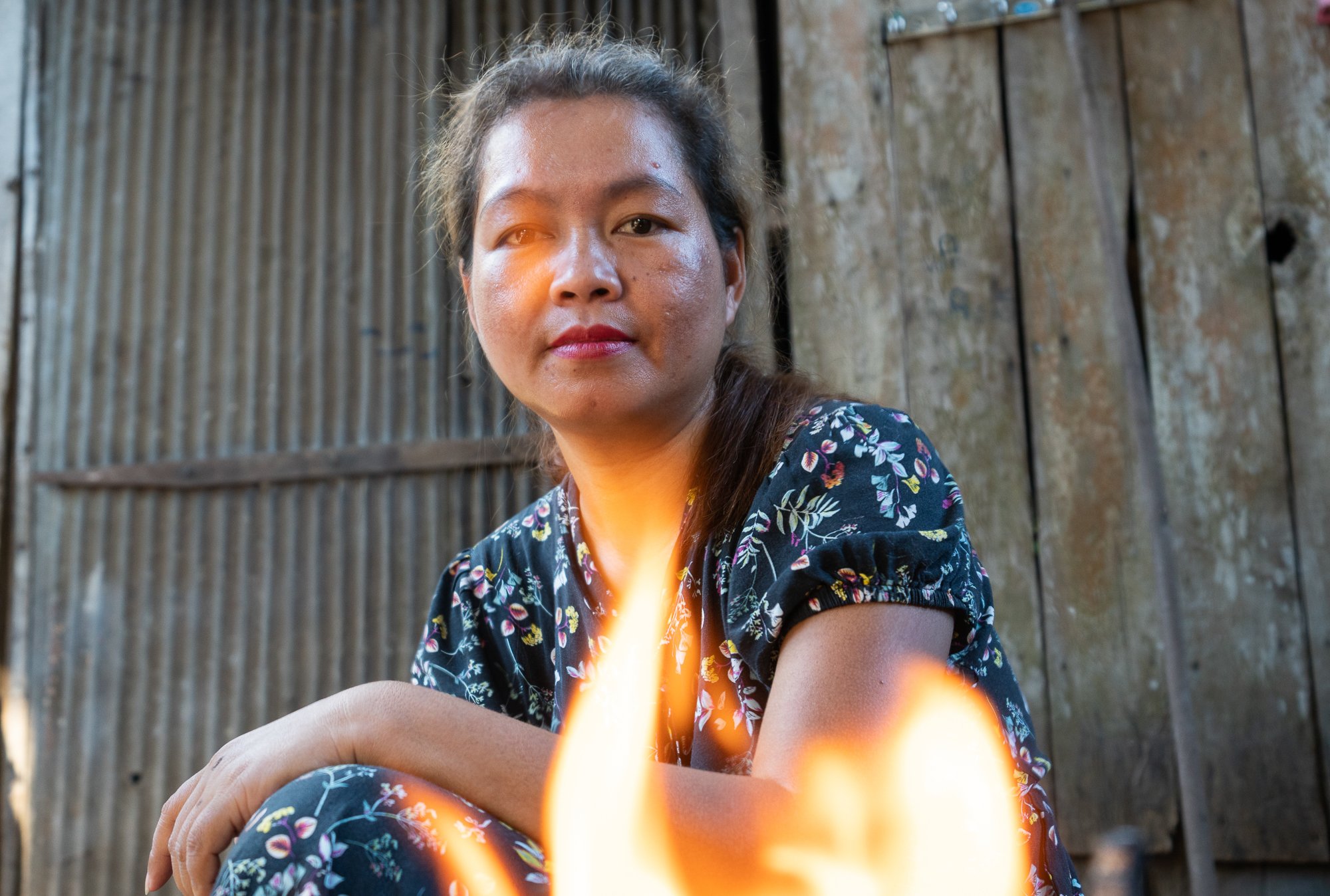 San Sotheary looking through the flames of her ACE cooker, photo assignment for the NGO Kiva in Siem Reap