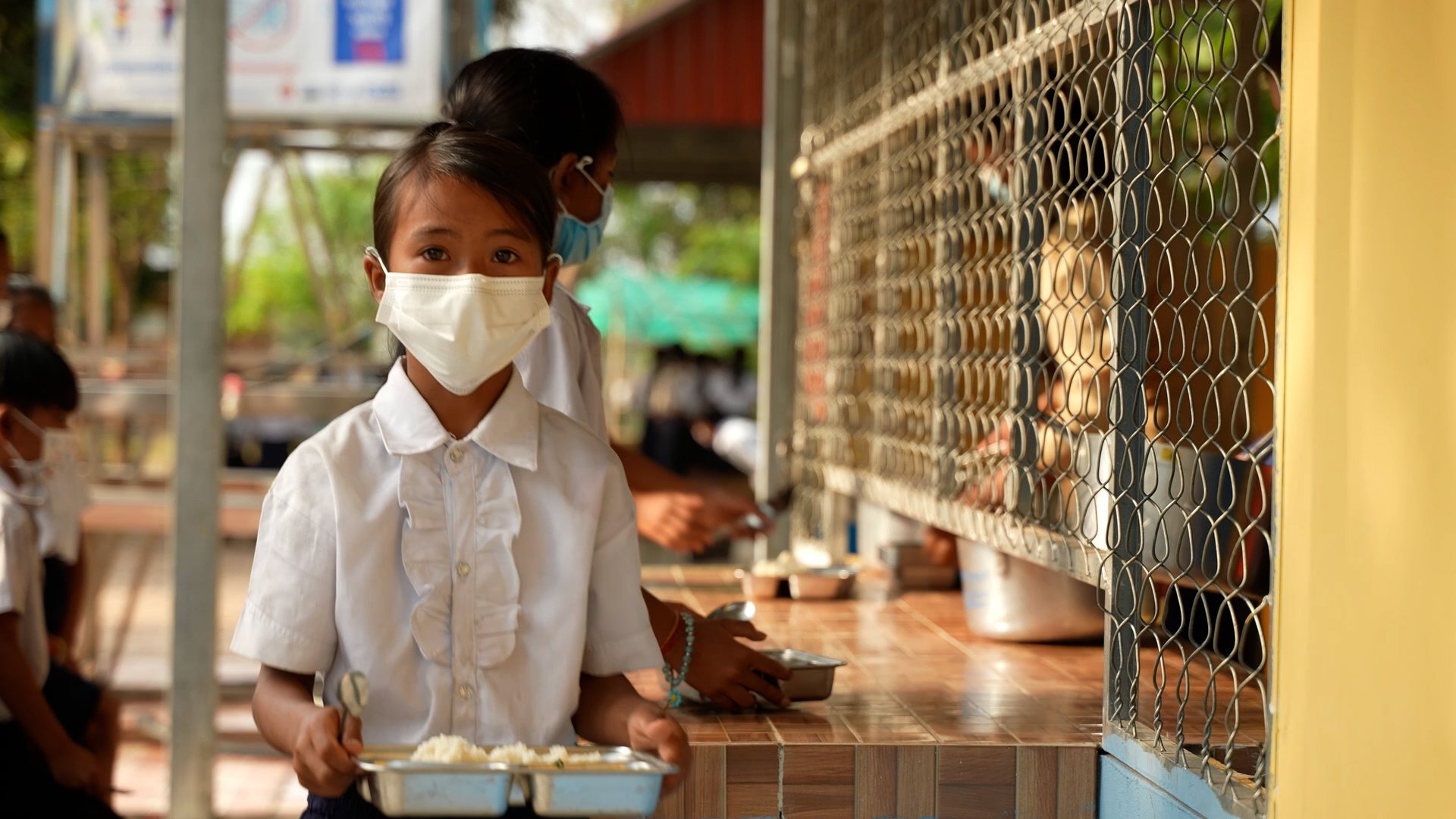 Girl stands with her school meal, WFP school feeding programme Siem Reap