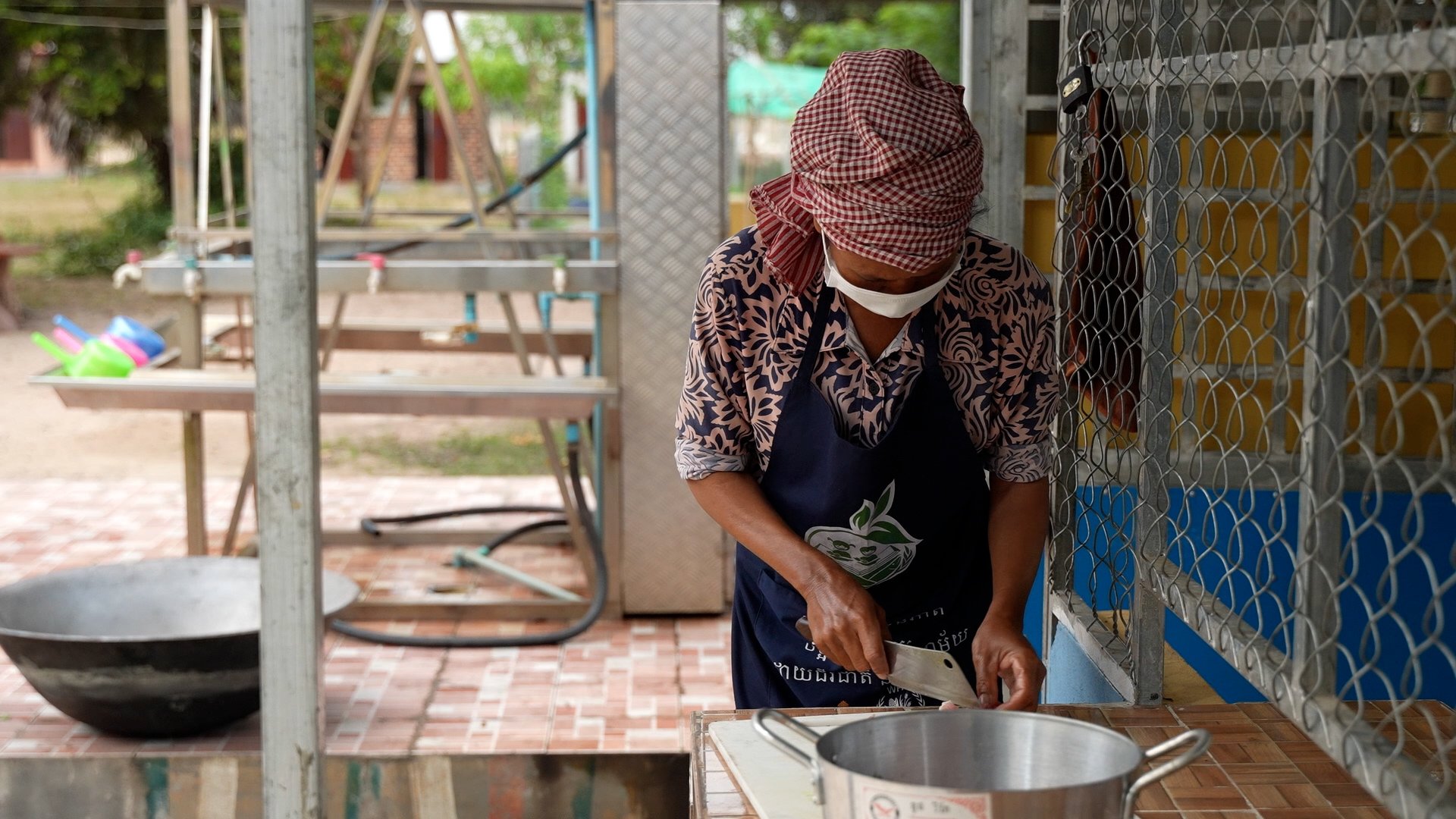 School cook cuts meat, WFP Cambodia School Feeding Program