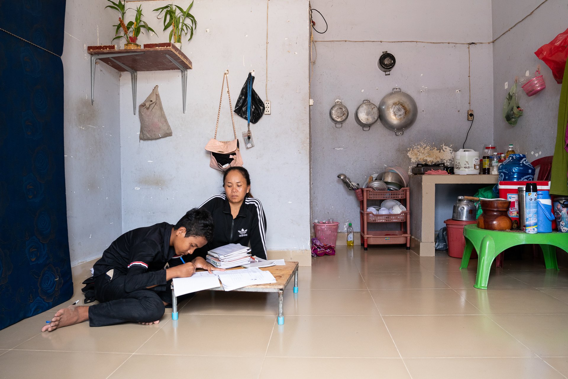 Sok Voeun doing homework with her son at home