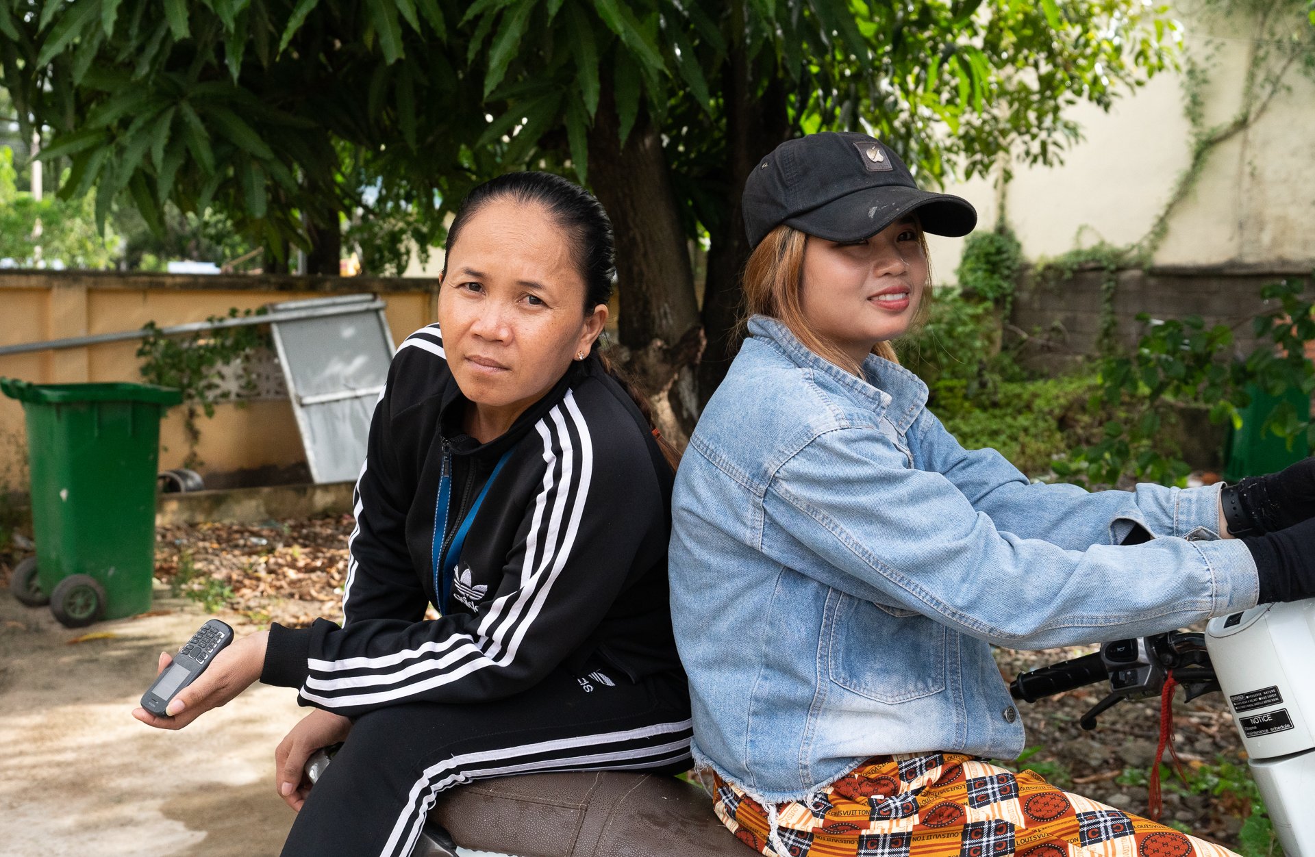 Sok Voeun and her sister sitting on her sister's motorbike outside the healthcentre