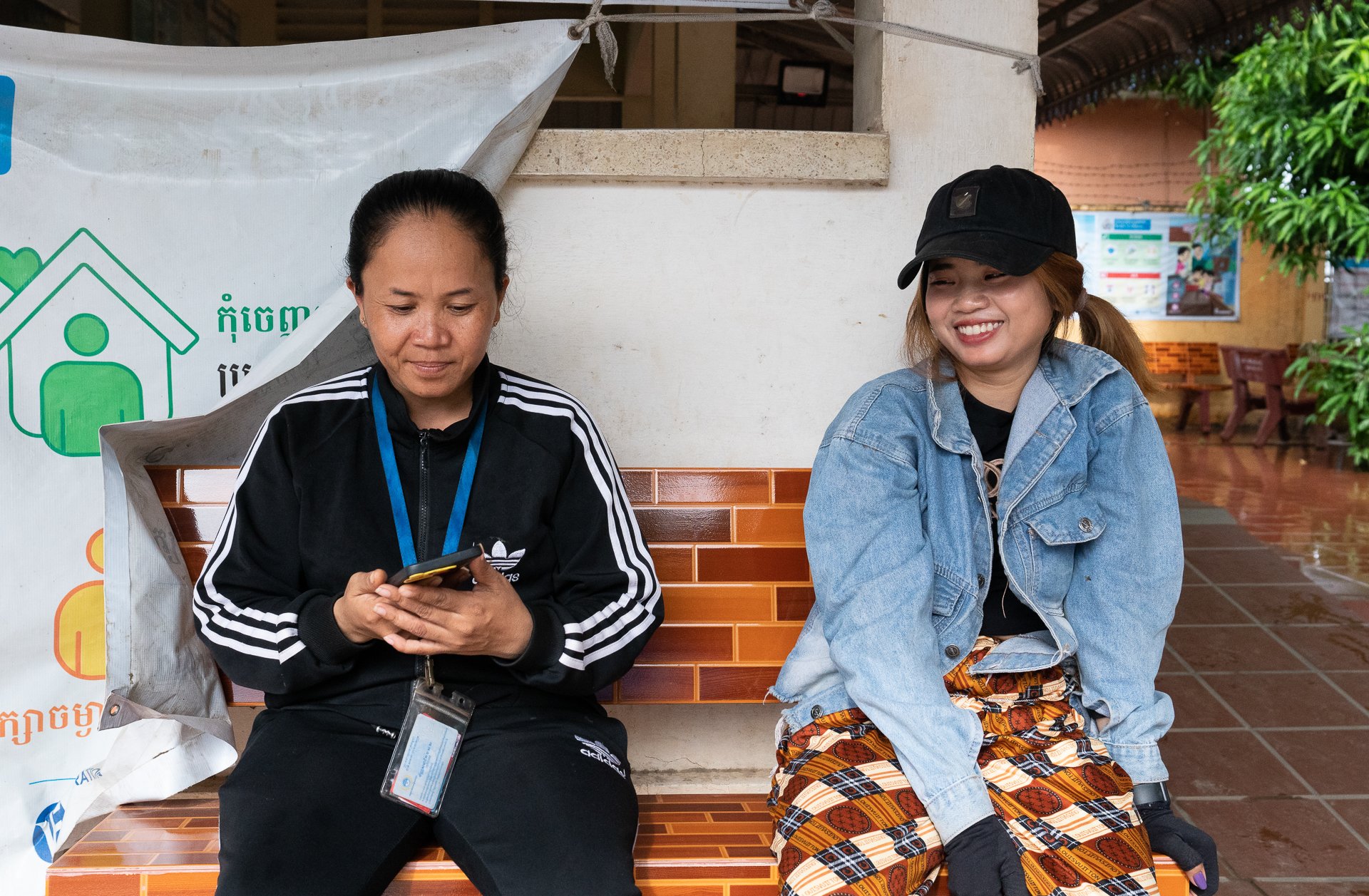 Sok Voeun and her sister sat on a bench outside the healthcentre