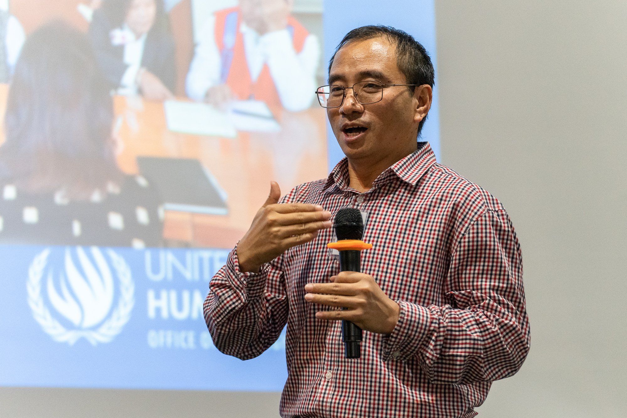A male UN staff member presents during a YECAP training session