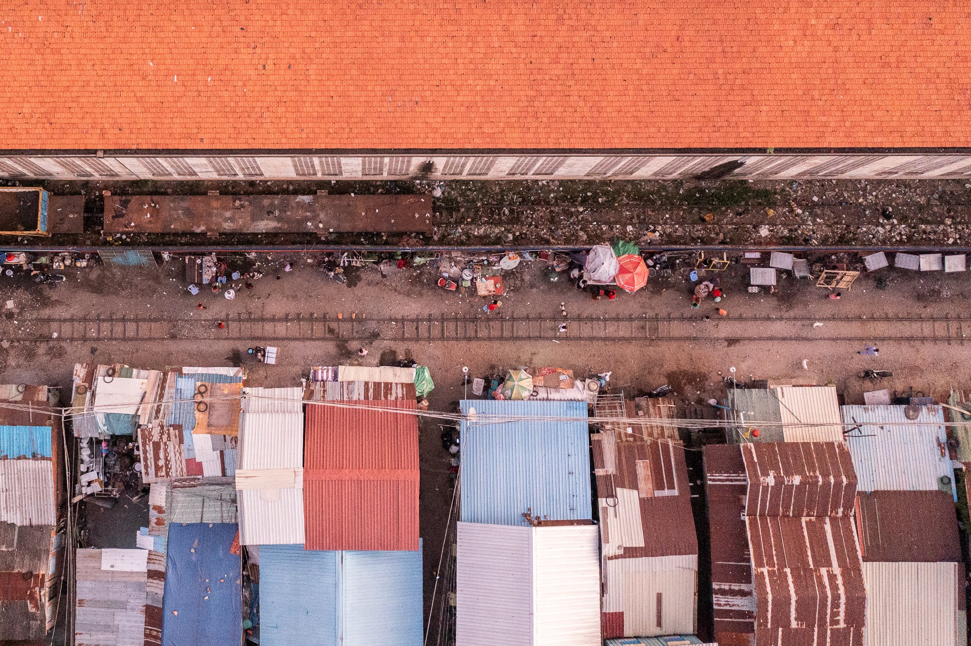 A top down view of the rail tracks with metal shacks and the Cambodia Railways buildiing on either side of the tracks, Phnom Penh, Cambodia